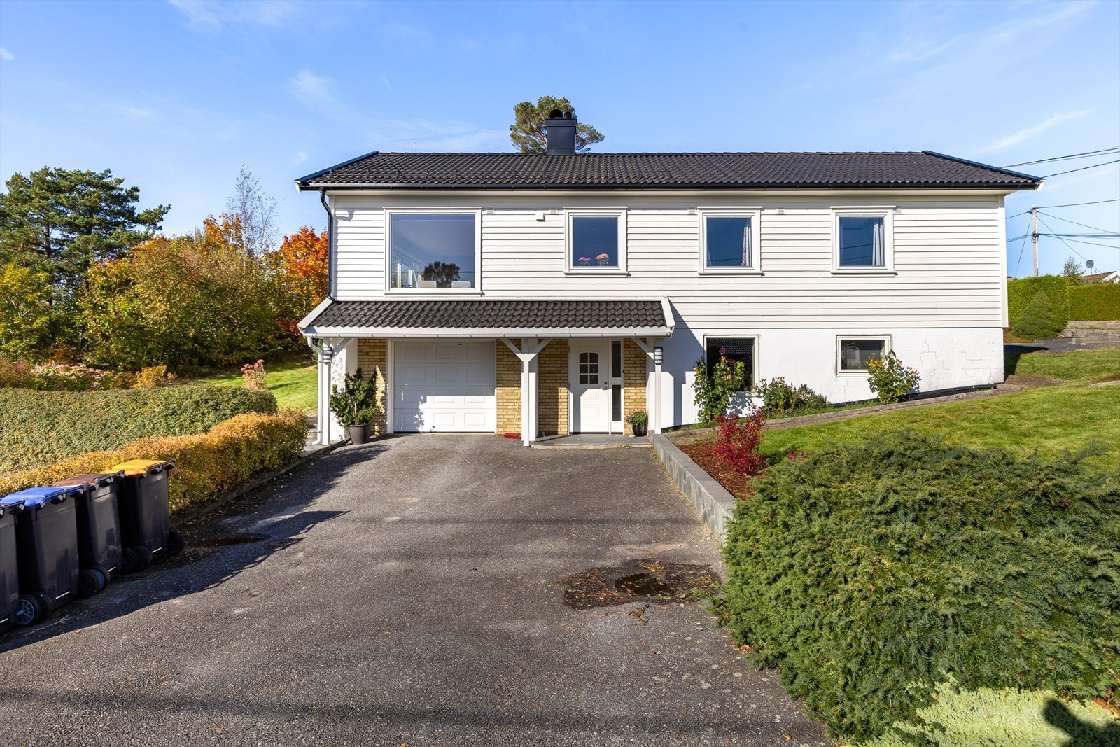 Boligen har integrert garasje og bred asfaltert oppkjørsel med plass til flere biler Galleribilde