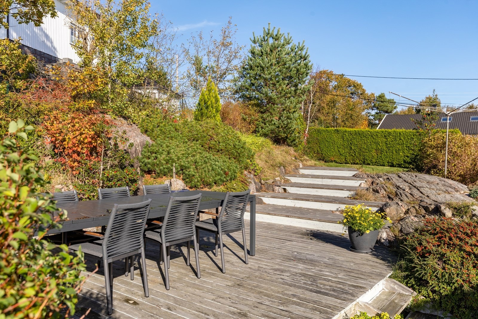 Det er lunt og gode solforhold på uteplassen og hage bak huset Galleribilde