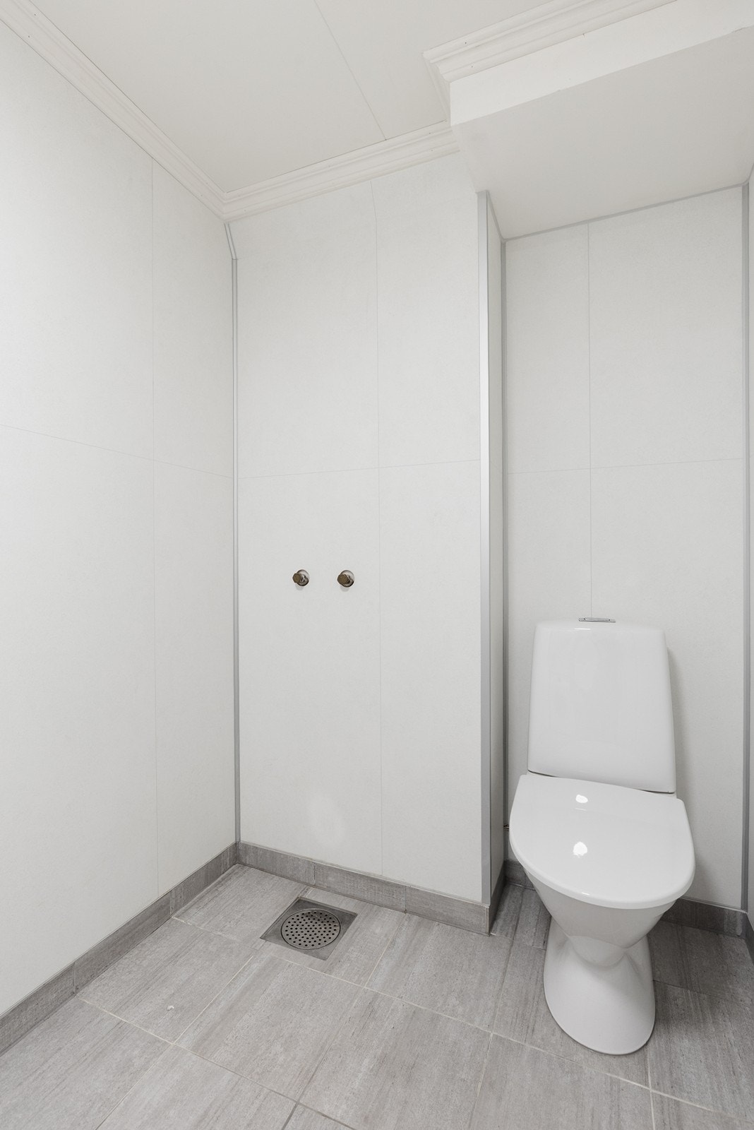 Gulvmontert wc på vaskerommet med røropplegg og sluk i gulvet for evt dusj. Galleribilde