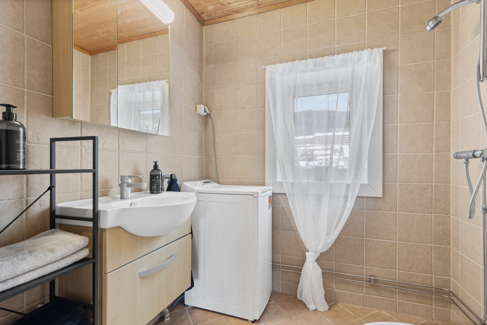 Badet er innredet med vegghengt servantinnredning, speilskap med overlys og gulvstående toalett Galleribilde