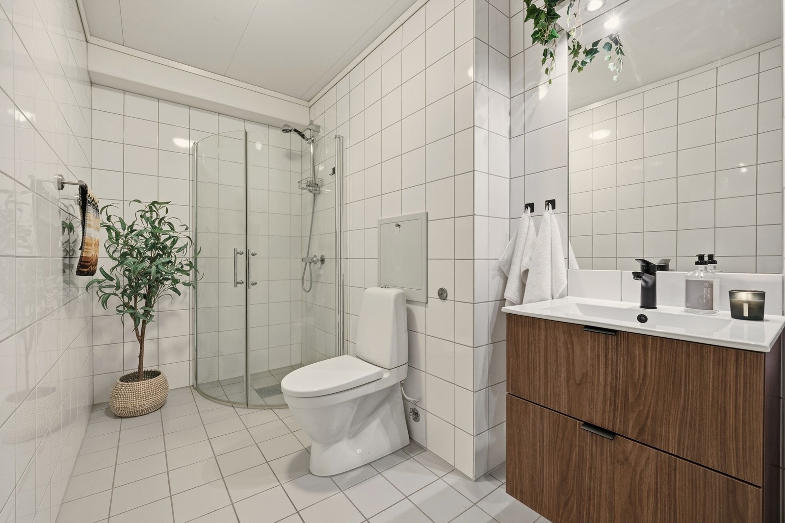 Badet er utstyrt med nyere servant og skuffeseksjon, speil med lys, dusjnisje og toalett Galleribilde