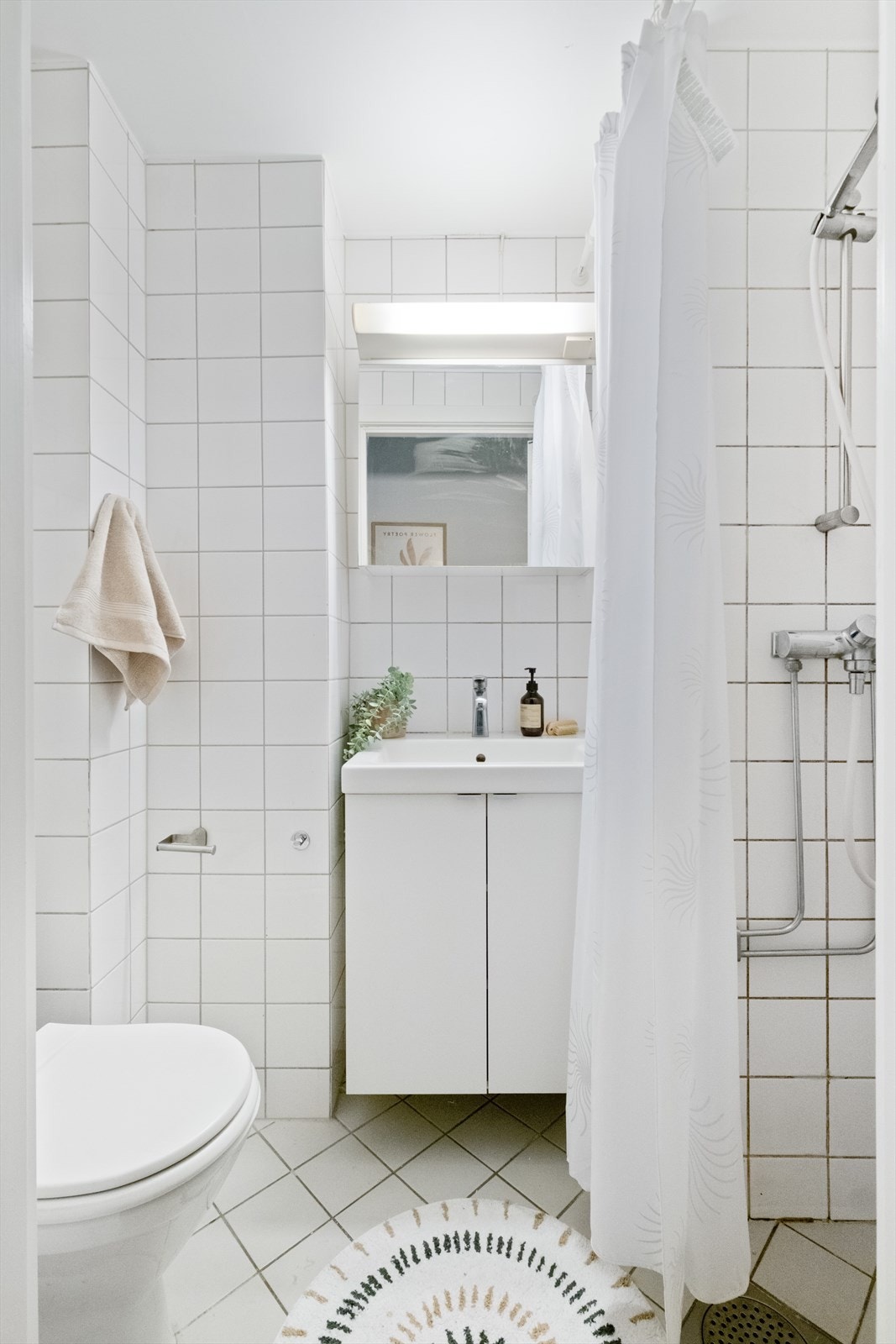 Flislagt bad/wc med varmekabler, avtrekk, speilskap, armatur, servant med innredning, dusj hjørne med forheng, toalett. Galleribilde