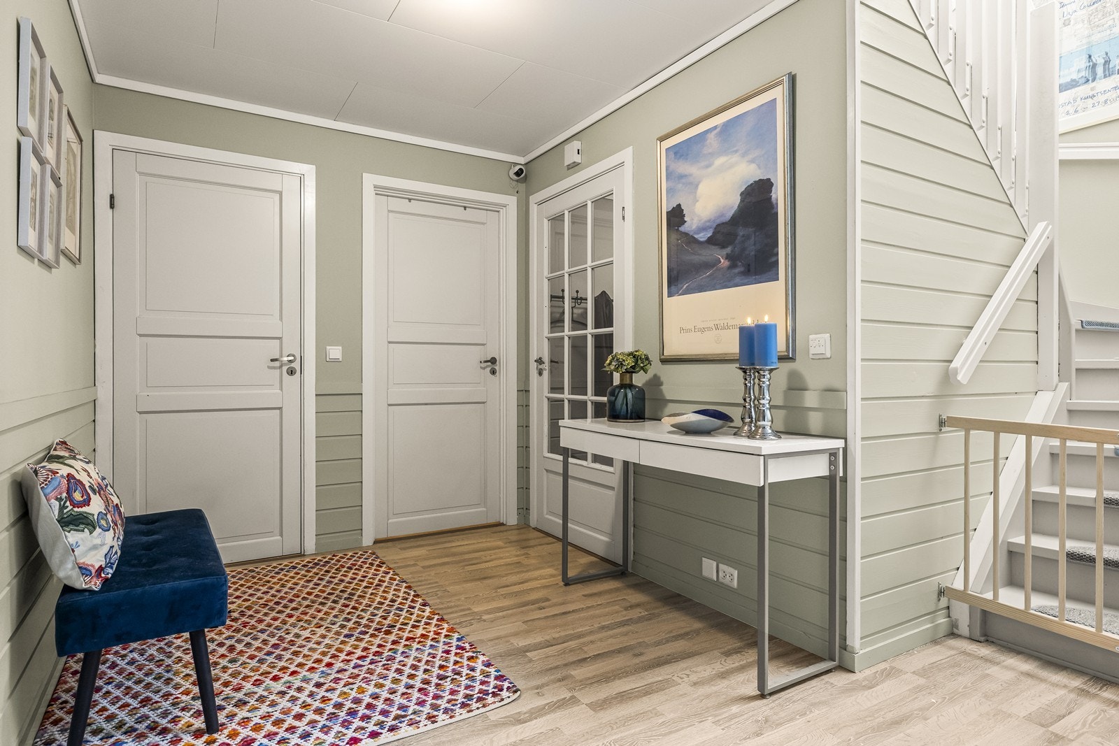 Fra gangen ledes du videre inn i en mellomgang, adskilt med en glassdør som slipper inn lys og skaper et pent skille mellom inngangspartiet og resten av boligen. Galleribilde