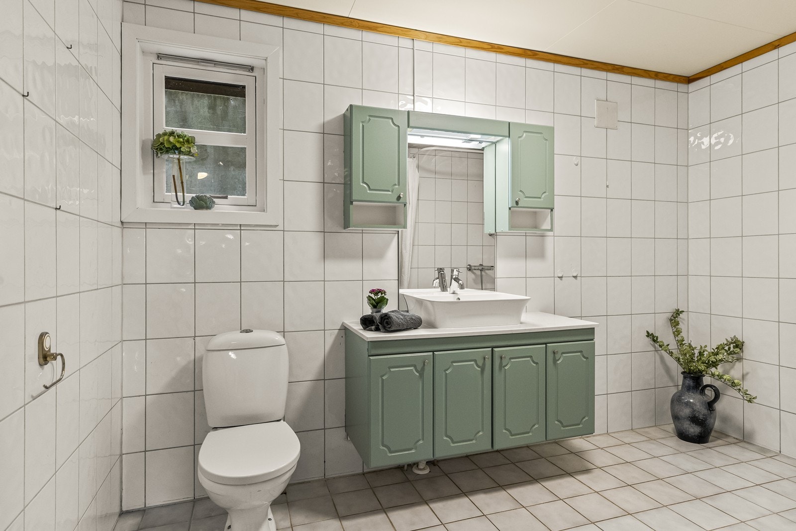 Boligens baderom ligger i 1. etasje og fremstår som et stort og romslig rom med flislagte overflater på både gulv og vegger. Det er lagt varmekabler i gulvet, som gir en behagelig temperatur året rundt. Galleribilde