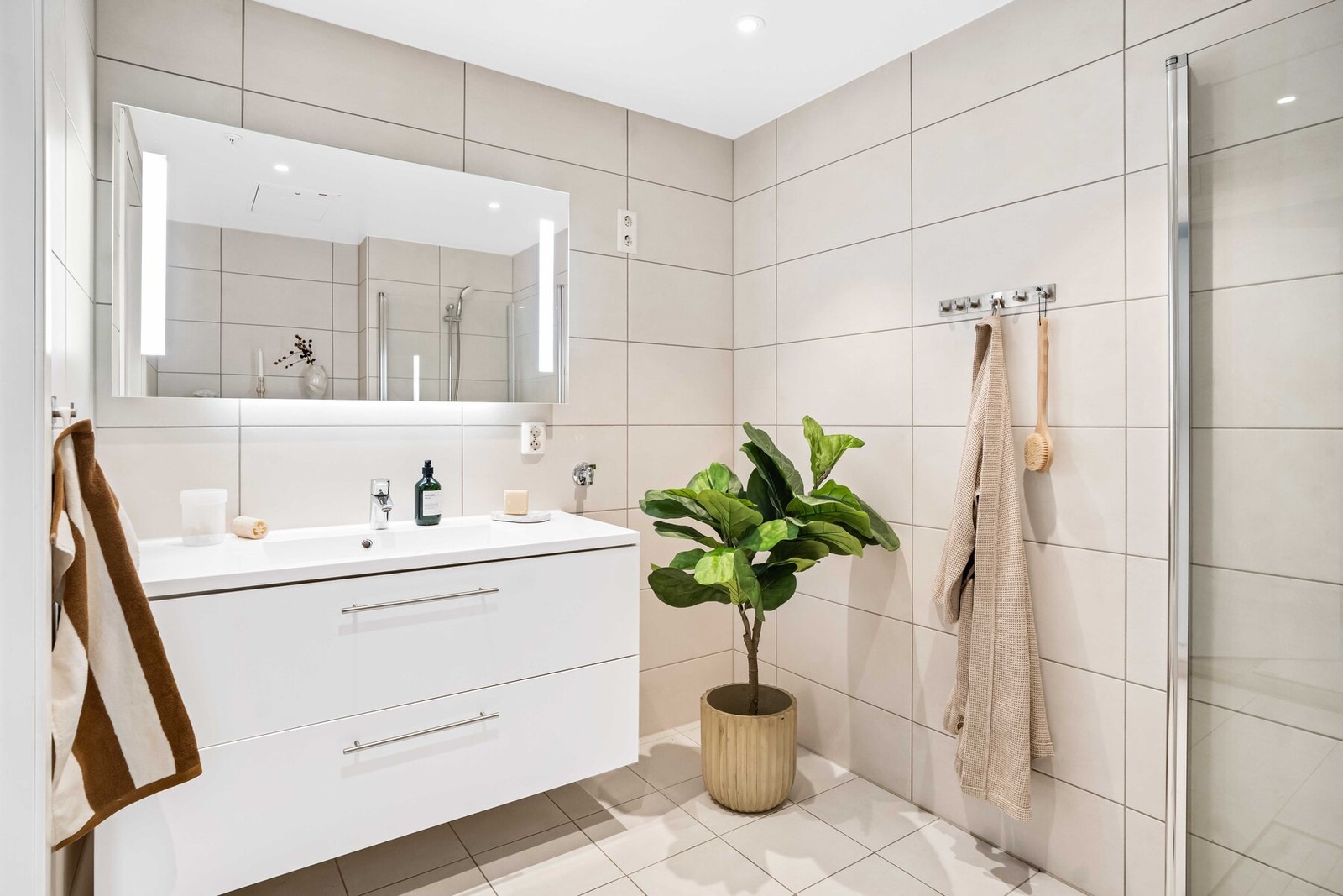 Delikat flislagt bad med en tidløs innredning samt praktiske løsninger. Galleribilde