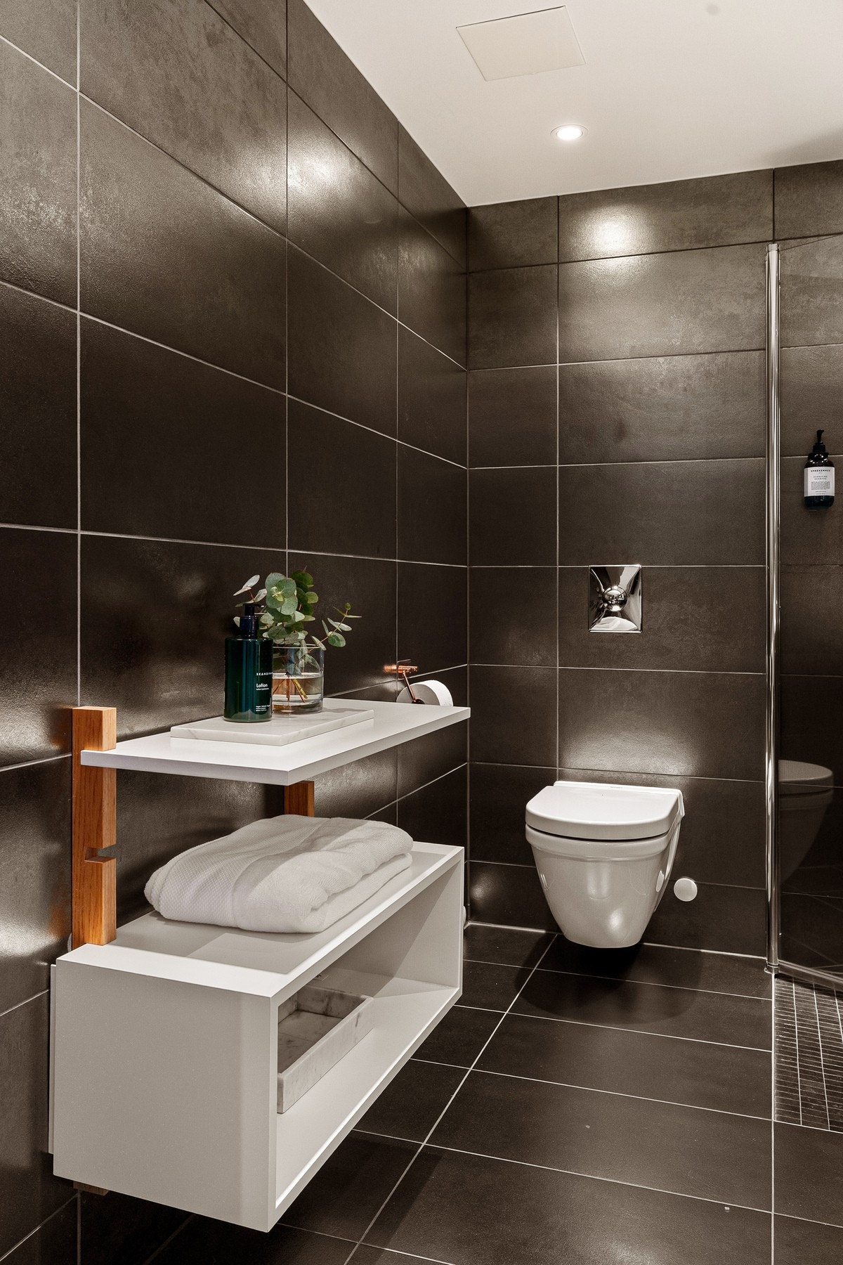 Baderommet er også utstyrt med vegghengt toalett og dusjhjørne med innfellbare glassdører. Galleribilde