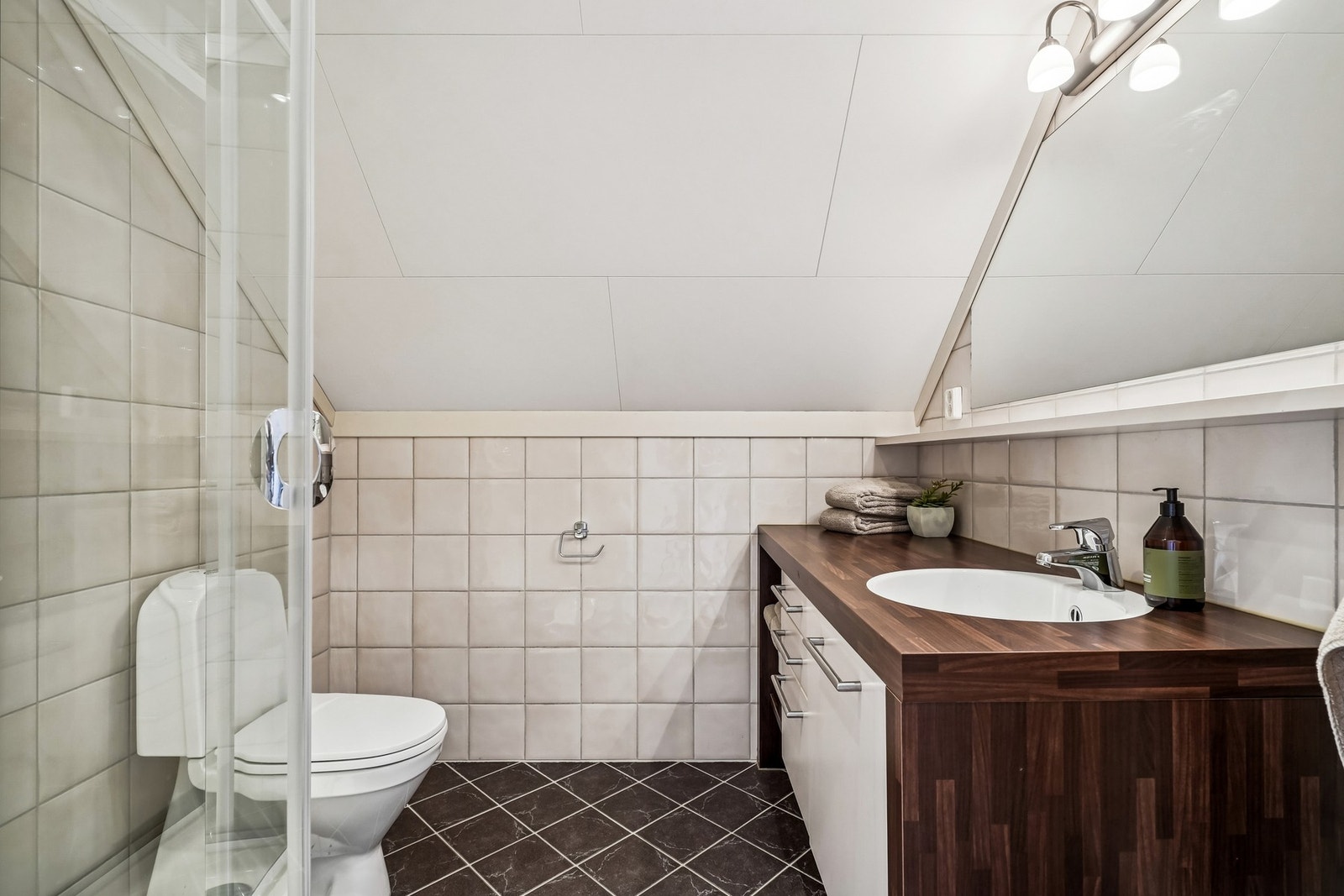 Flislagt bad med varmekabler, wc, dusj og servantinnredning på garasjeloftet. Galleribilde