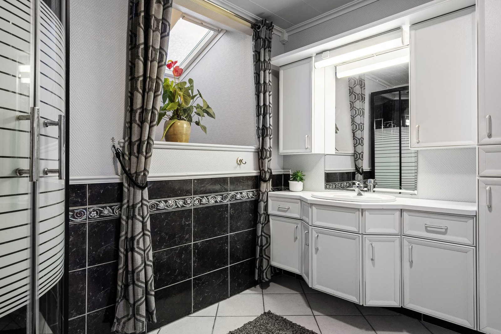 Velholdt bad med flislagt gulv og vegger - enkelt, lyst og funksjonelt. Galleribilde