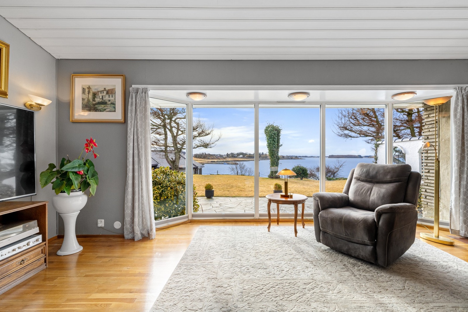 Store vinduer i stuen slipper inn rikelig med lys og rammer inn den spektakulære sjøutsikten. Galleribilde