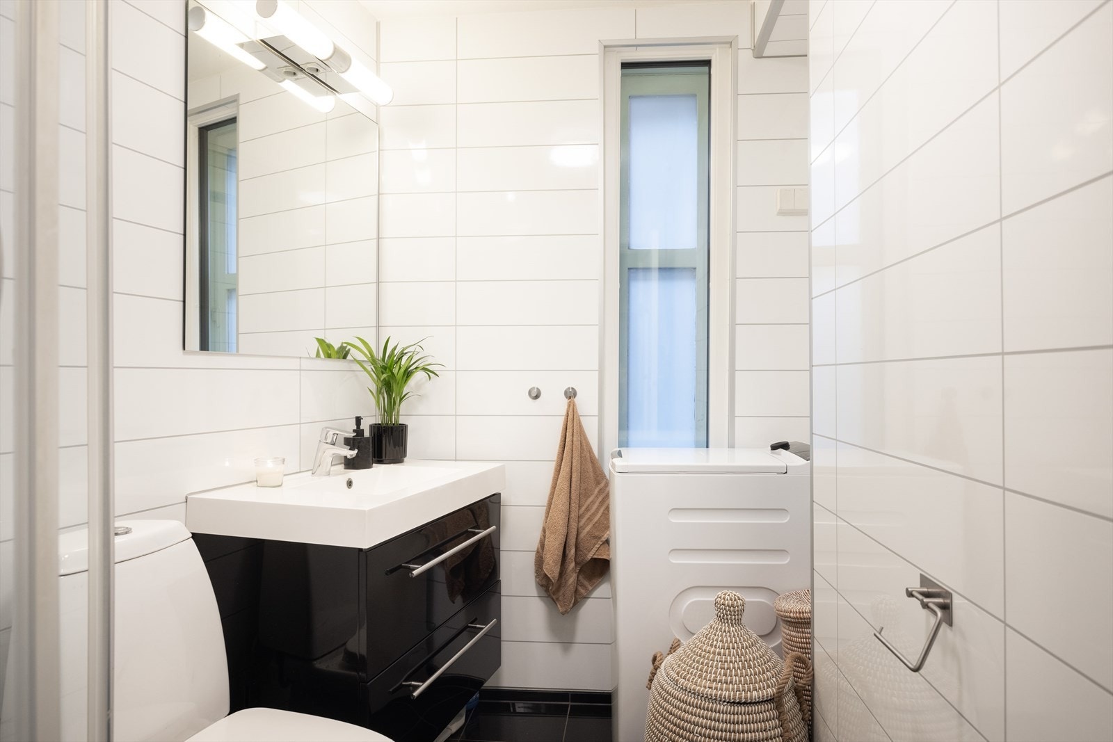 Pent bad med flislagt gulv og funksjonell innredning. Galleribilde