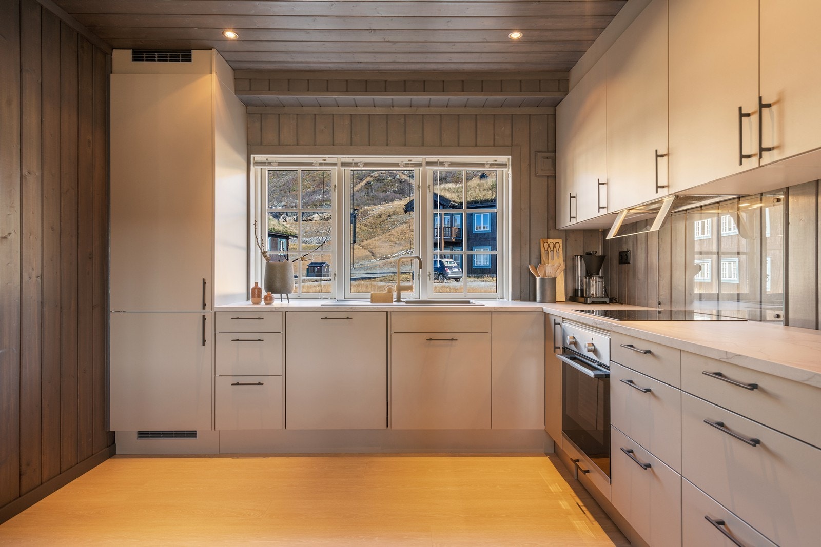 Kjøkkeninnredning med glatte fronter og benkeplate av laminat. Kjøkkenet er utstyrt med integrerte hvitevarer i form av kjøl/fryseskap, oppvaskmaskin (ny i 2024), platetopp og stekeovn. Galleribilde