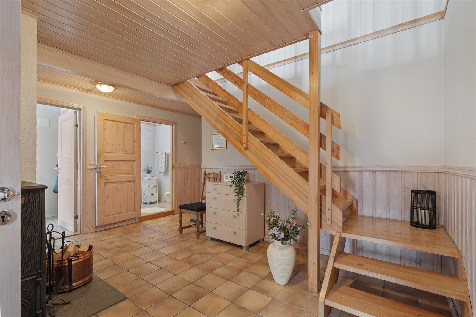 Stor og flislagt hall med vedovn og god plass til oppbevaringsmøbler. Galleribilde