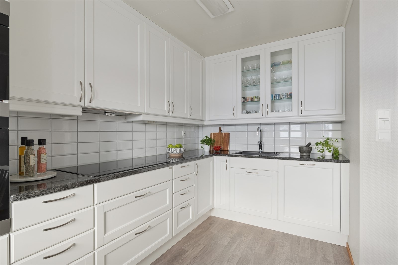 Stilren innredning med profilerte fronter og enkelte overskap med glassdører. Galleribilde