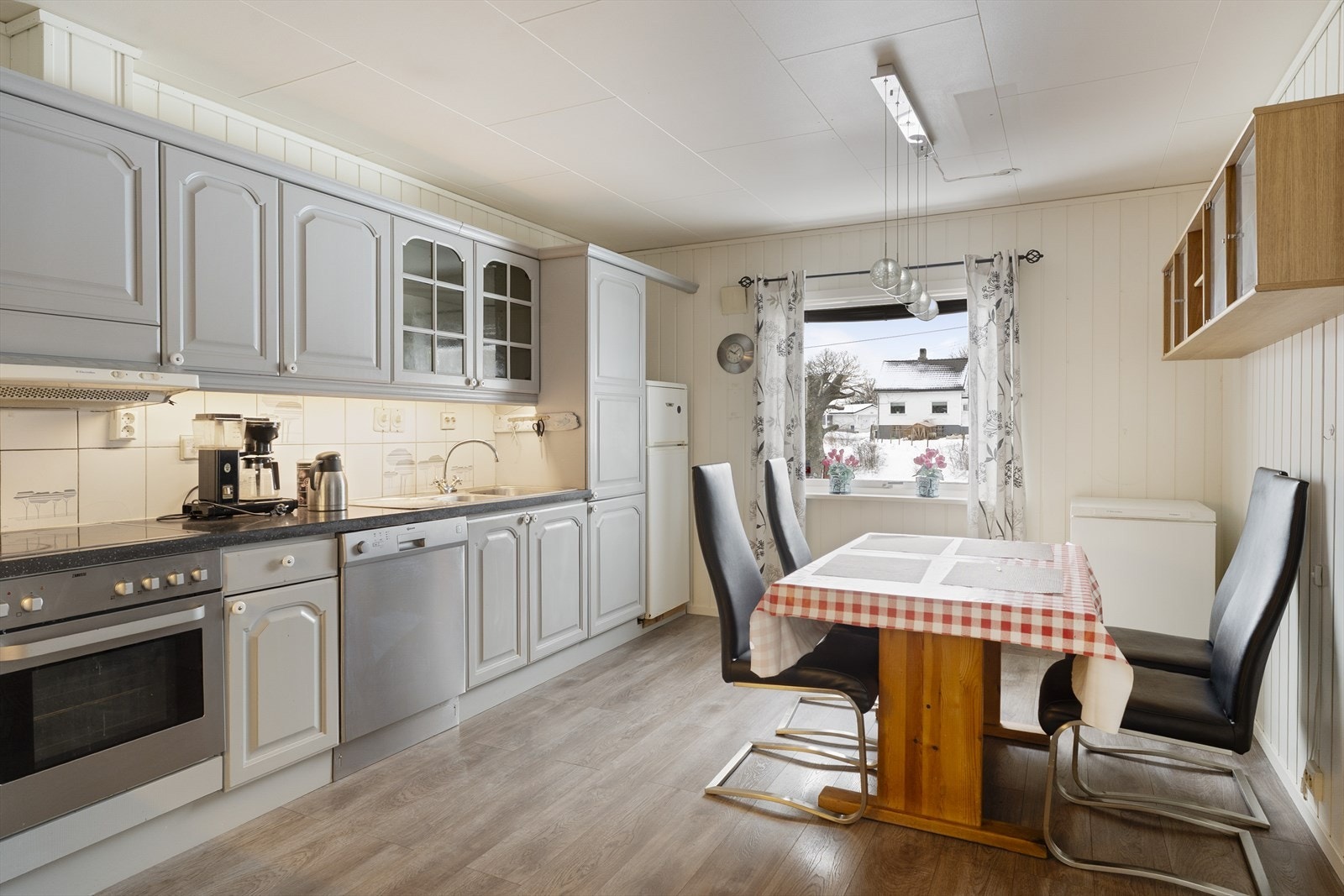 Kjøkkenet er utstyrt med integrert platetopp og stekeovn samt frittstående oppvaskmaskin og kjøl/fryseskap Galleribilde