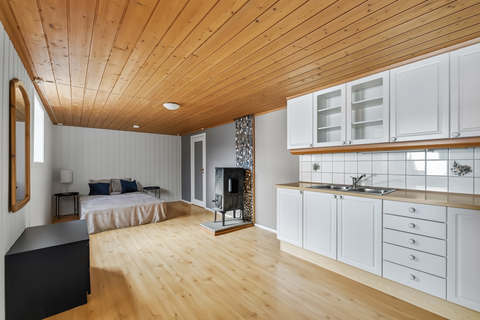 Kjøkkeninnredning med profilerte fronter. Fliser på vegg over benkeskap. Alkove innerst i bildet. Galleribilde