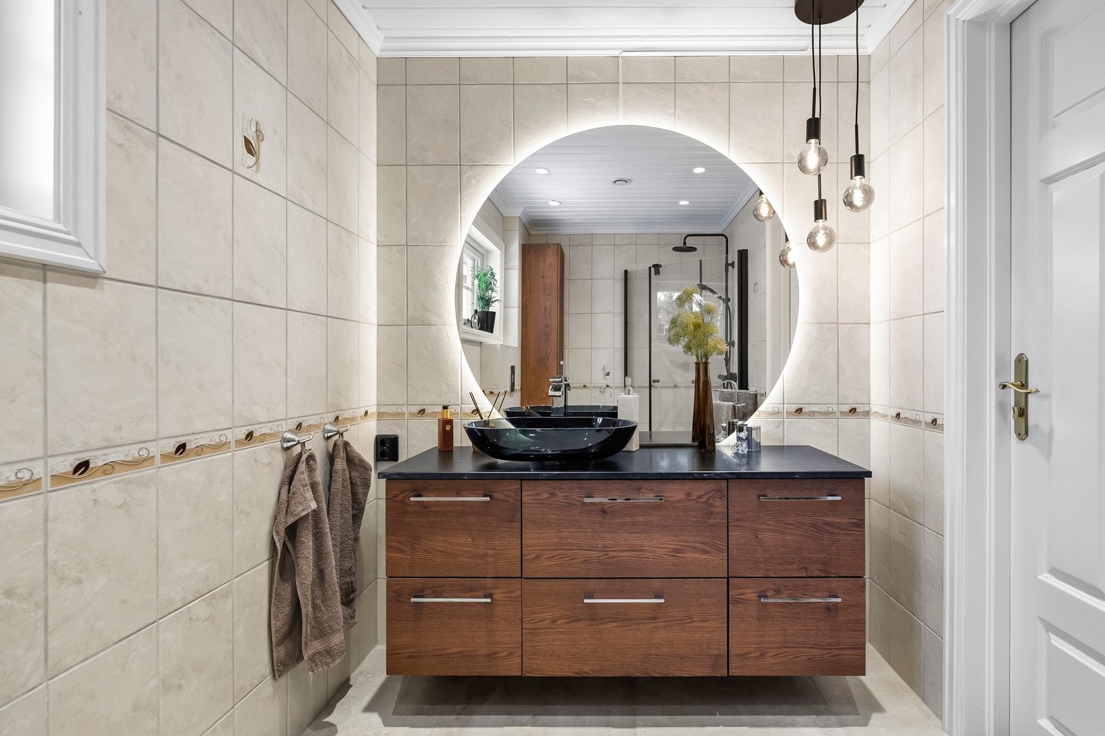 Badet er både lyst og innbydende. Servant, vegghengt klosett og dusj på gulv. Galleribilde