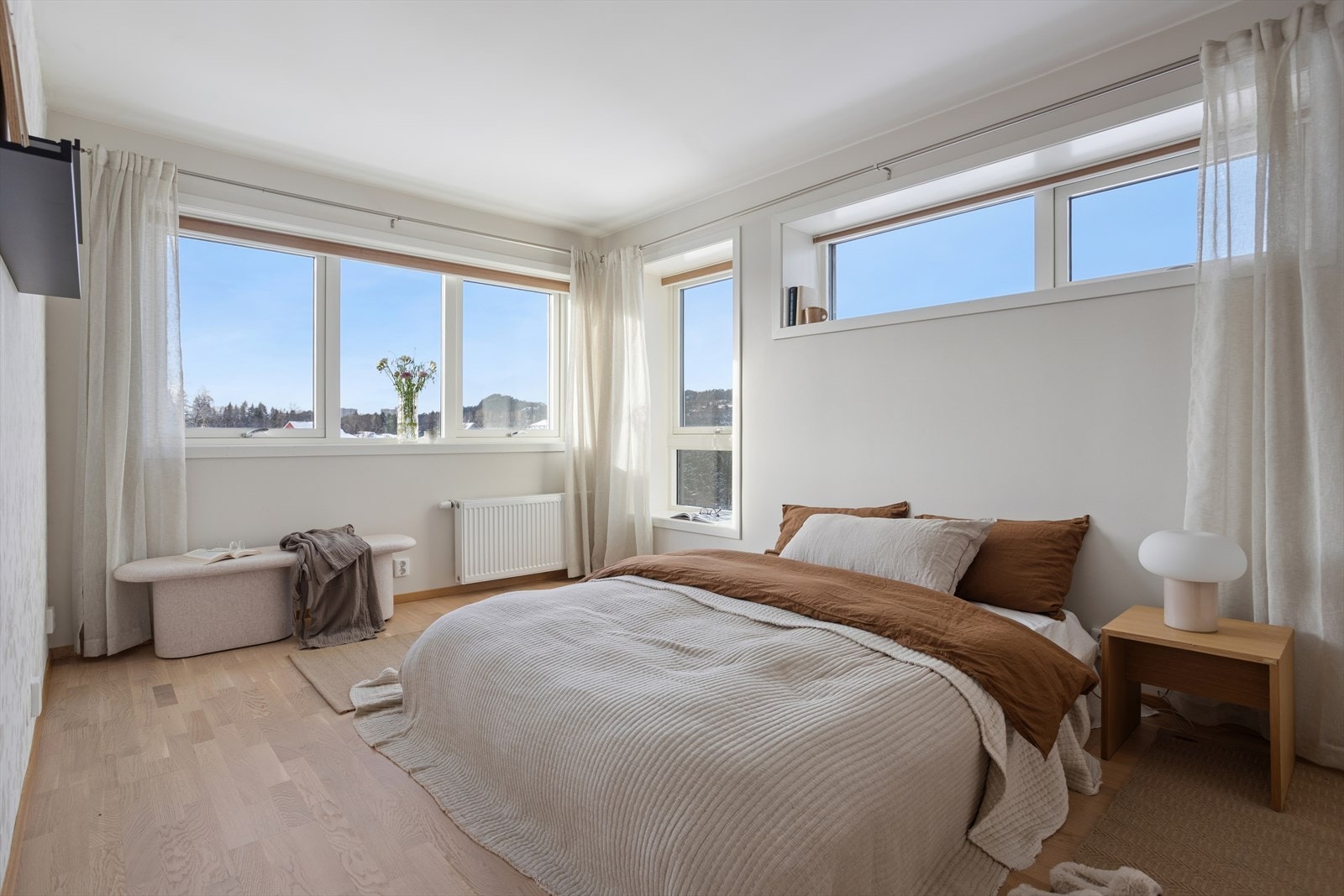 Lyst og trivelig hovedsoverom med store vindusflater og radiator Galleribilde