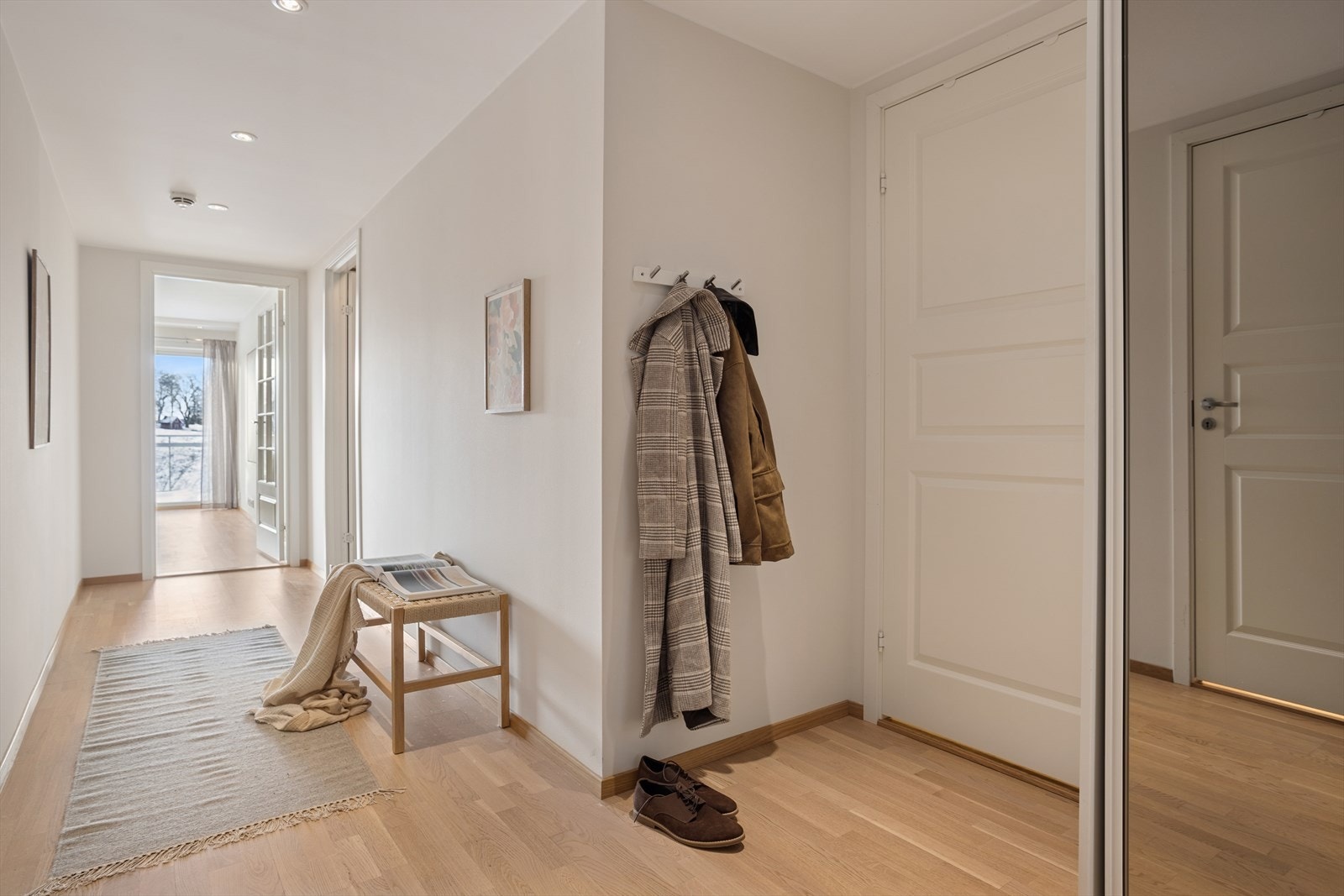 Romslig gang på 10,8 m² med skyvedørsgarderobe og god plass til å henger fra seg yttertøy. Gulvvarme og spotter i tak. Galleribilde