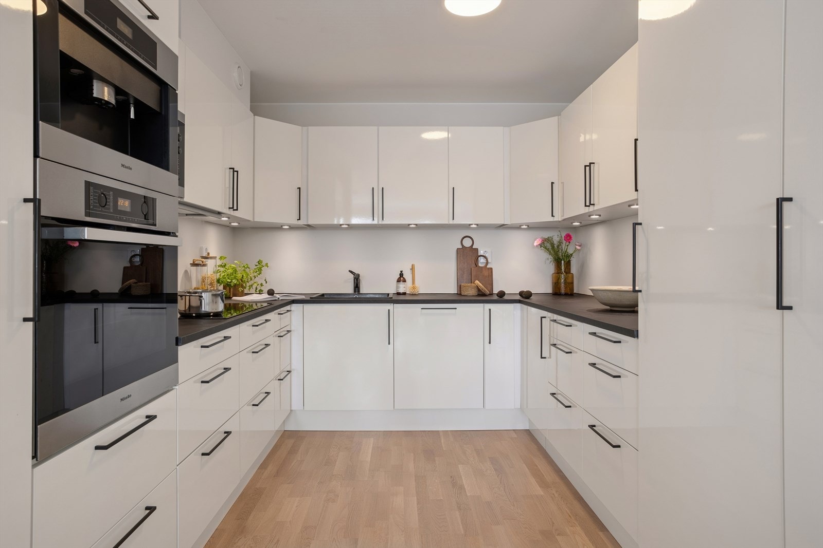 Pen kjøkkeninnredning med god skap og benkeplass Galleribilde