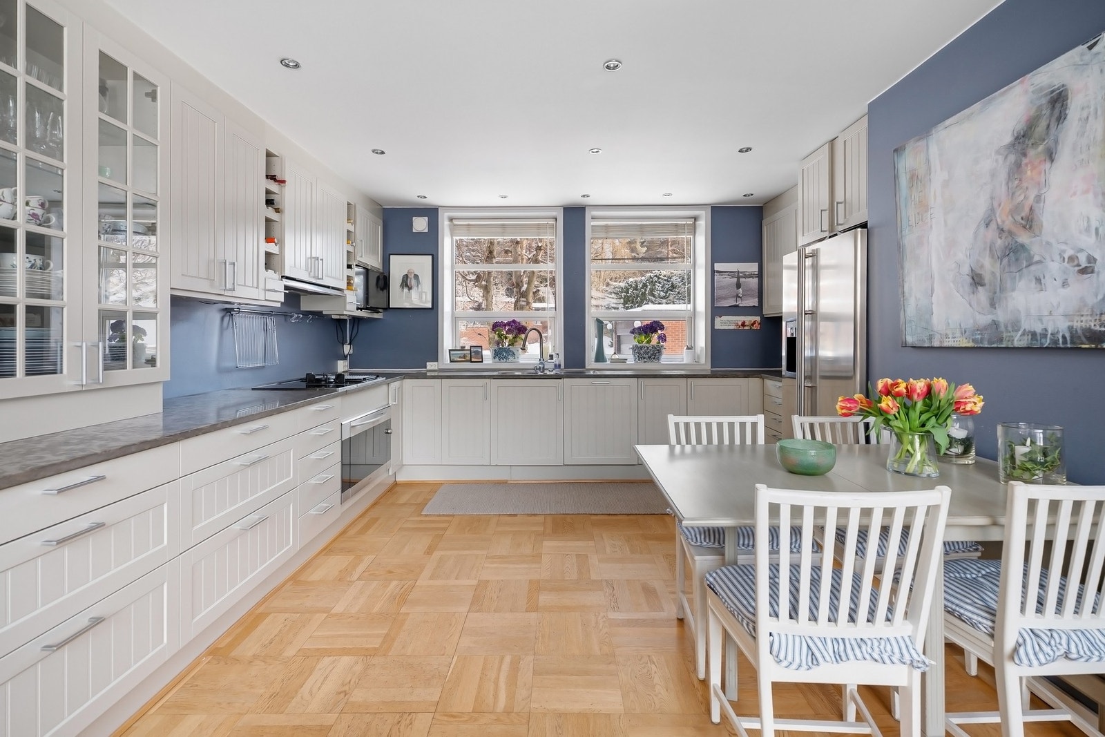 Marbodal malt innredning med profilerte fronter og glasskap. Benkeplater av natursten med nedfelt vaskekum og stor Mièle platetopp med kokeplater og gassbluss. Galleribilde