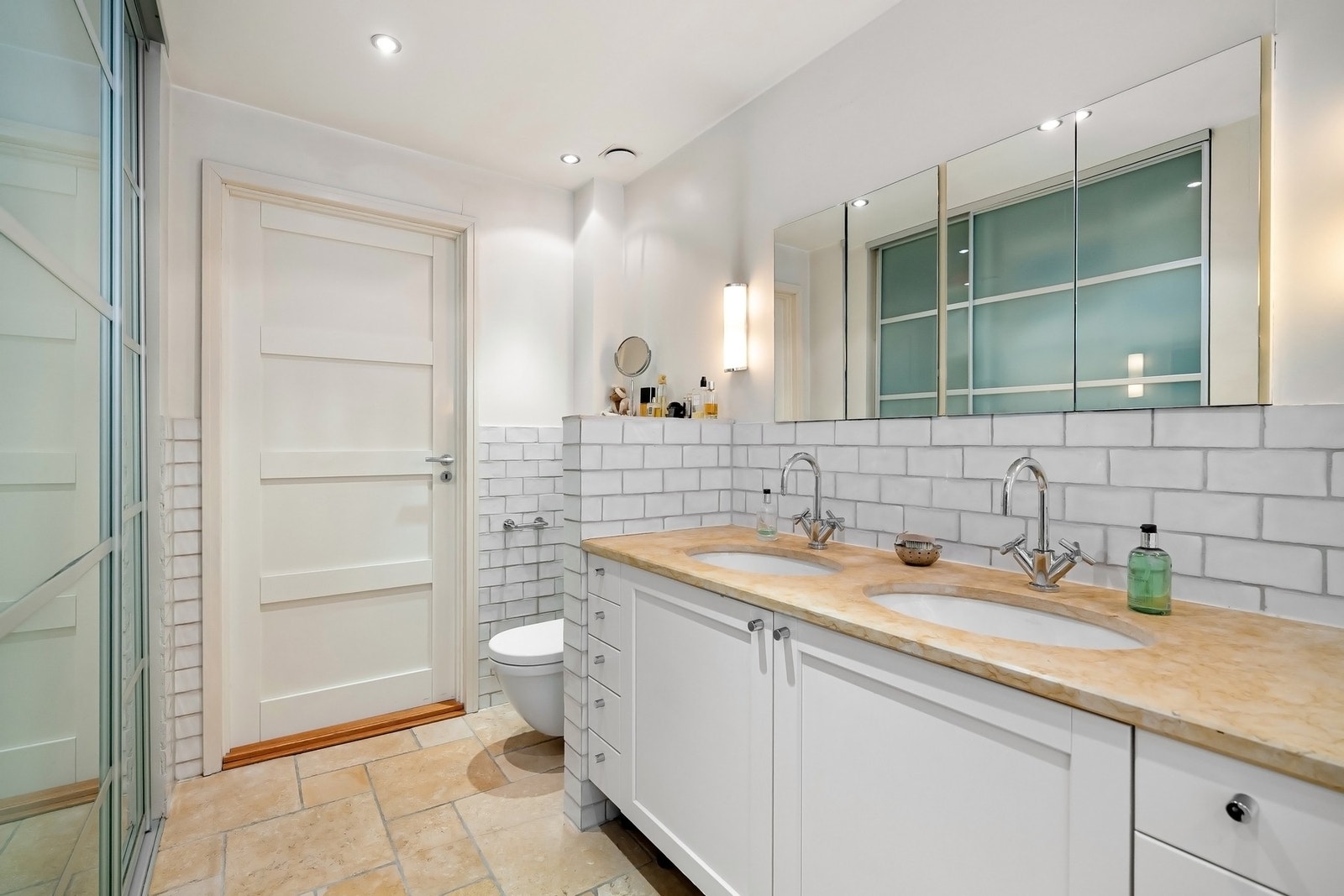 Innredning med malte skap og hel sten plate med 2 underlimte servanter og speilskap. Galleribilde