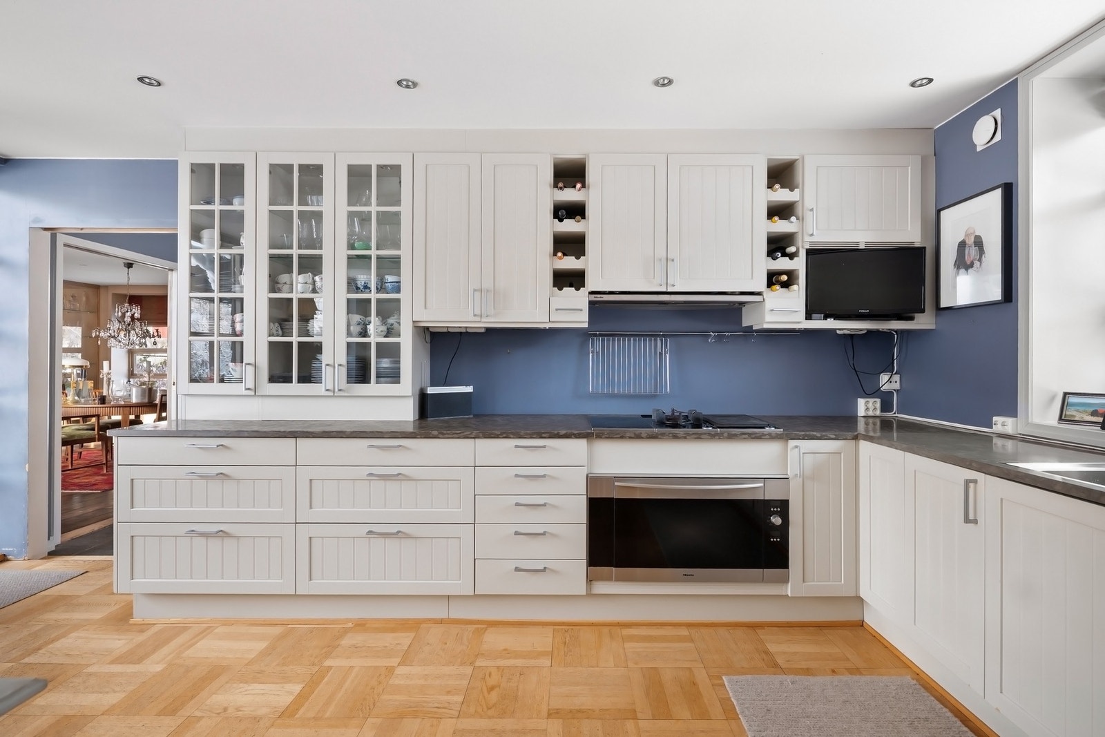 Integrerte hvitevarer fra Mièle med oppvaskmaskin, bred stekeovn og ventilator. Nisje for bredt kjøl/fryseskap. Galleribilde