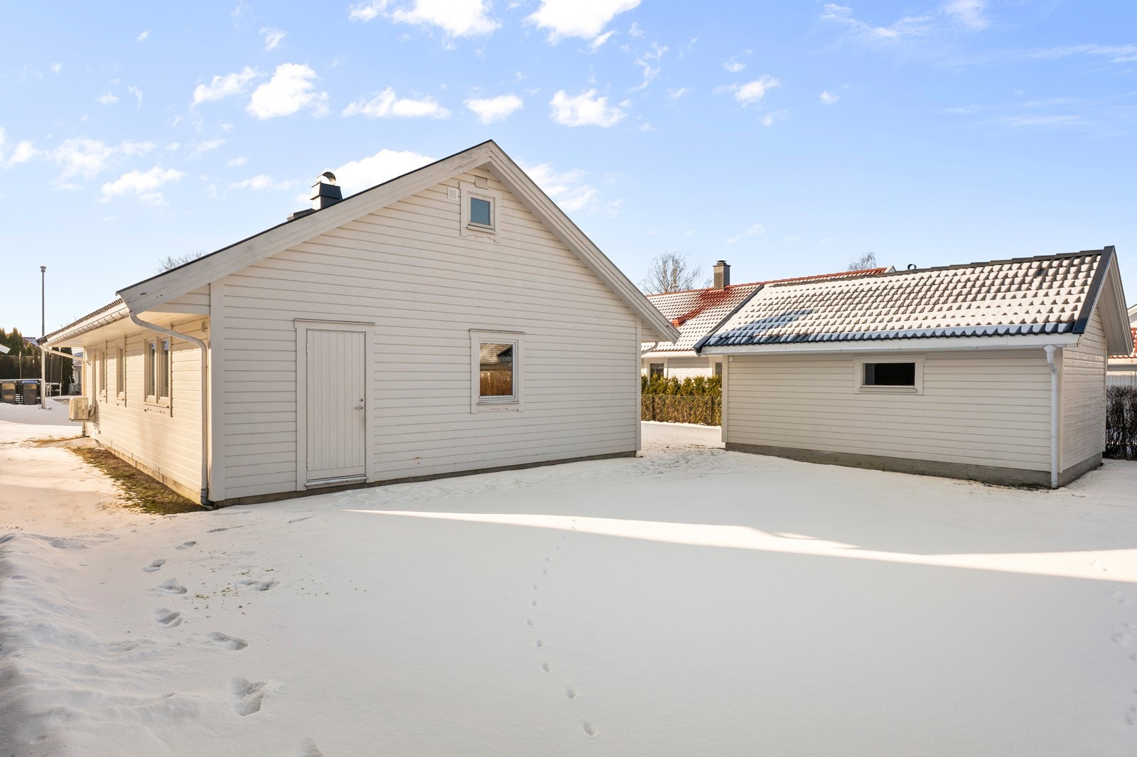 Eiendommen ligger på en flat tomt som er pent opparbeidet med plen og hekk. Galleribilde