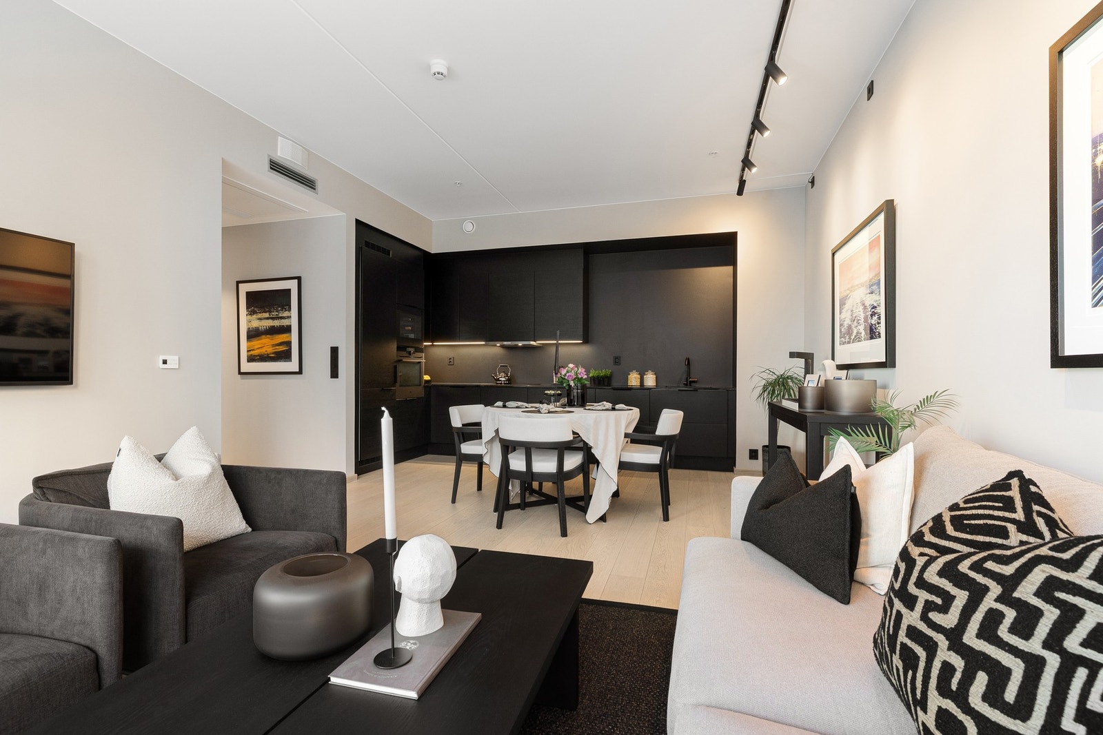 Rommet er lett å møblere og kan naturlig deles inn i soner, med spiseplass ved kjøkkenet og sofagruppe med stuebord og TV-benk foran vindusrekken. Galleribilde