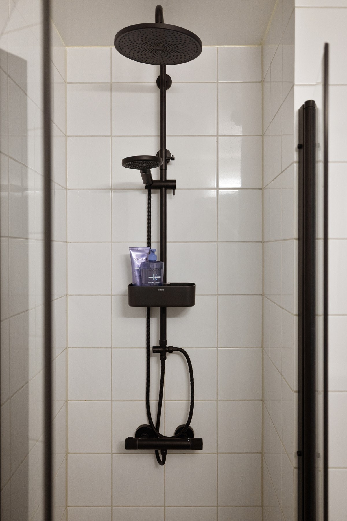 Praktisk dusjnisje med glassdører og sort armatur med både hånd- og regnfallsdusj. Galleribilde