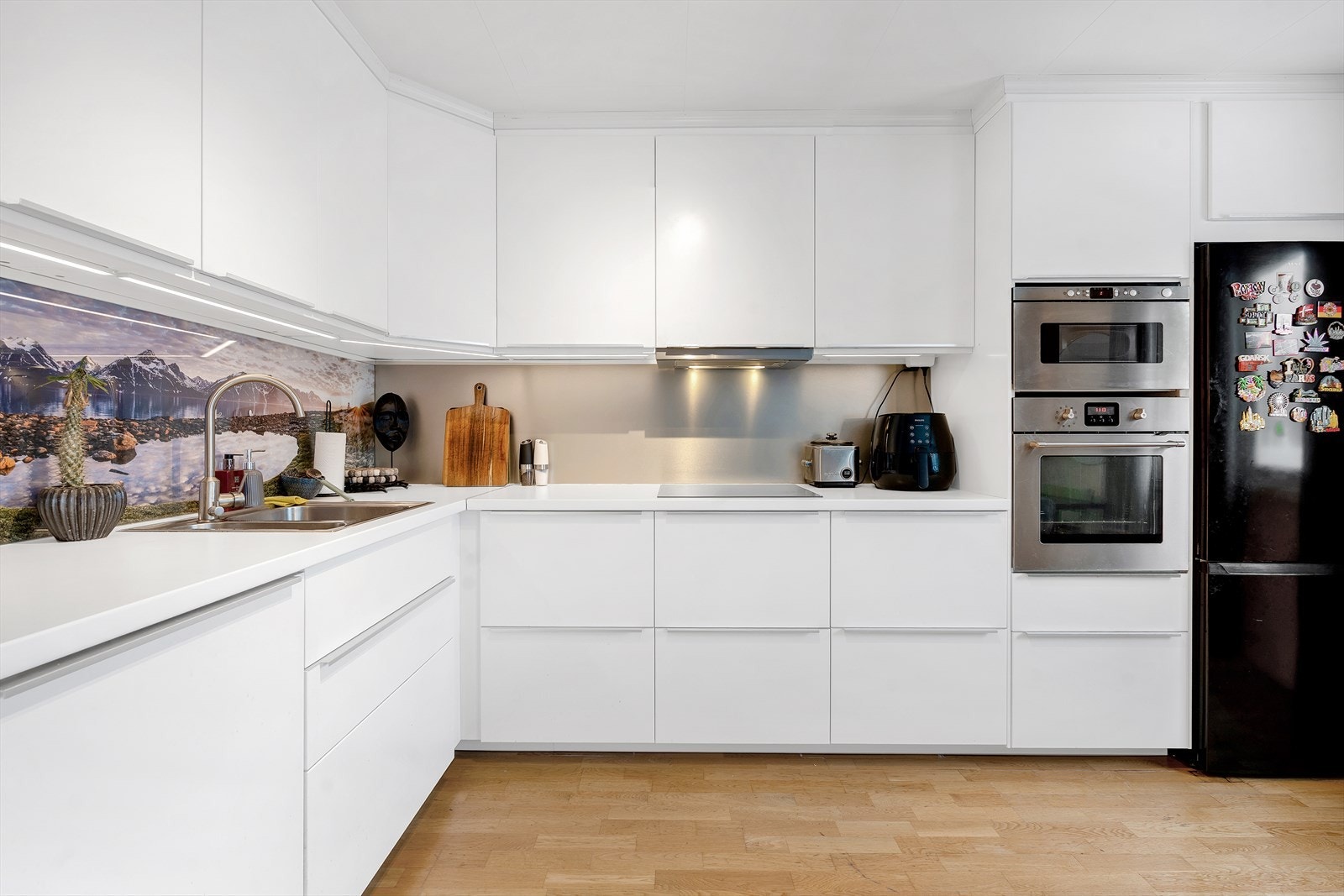 Flott og moderne kjøkken med mye skap og benkeplass samt integrert komfyr, koketopp og oppvaskmaskin. Galleribilde