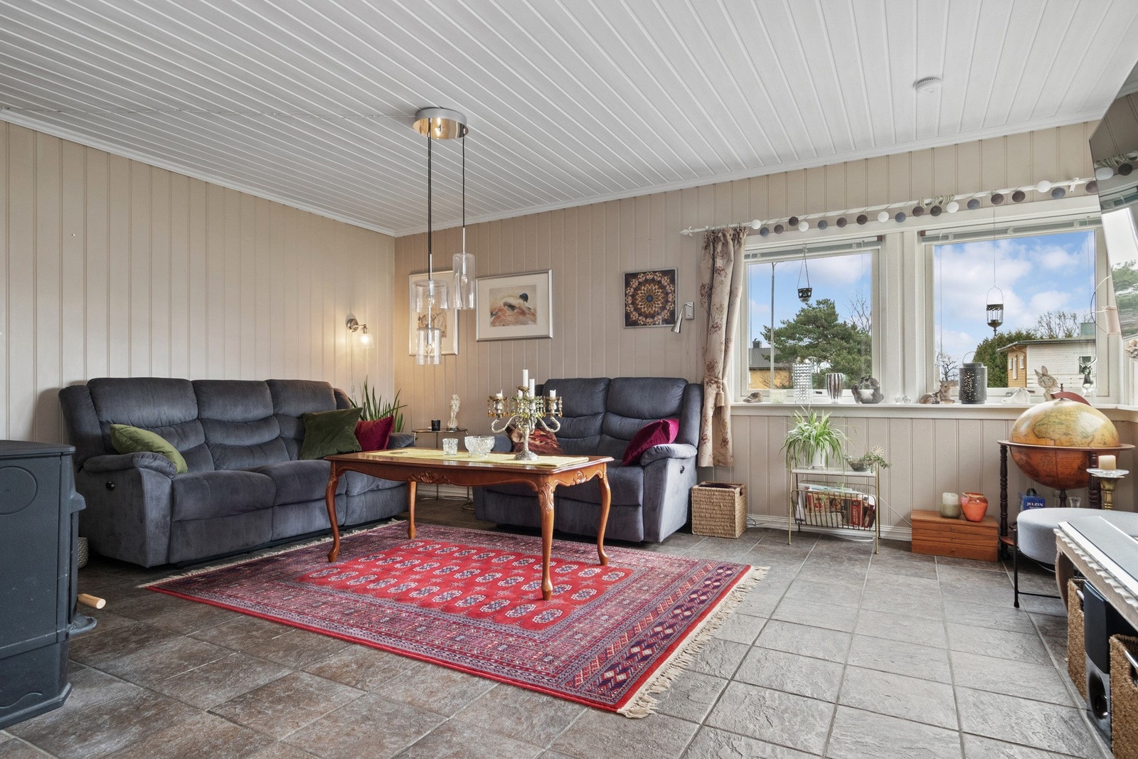 En peisovn er plassert i stuesonen og en nyere varmepumpe i den naturlige spisestuesonen, noe som tilfører både hygge og jevn innetemperatur. Galleribilde