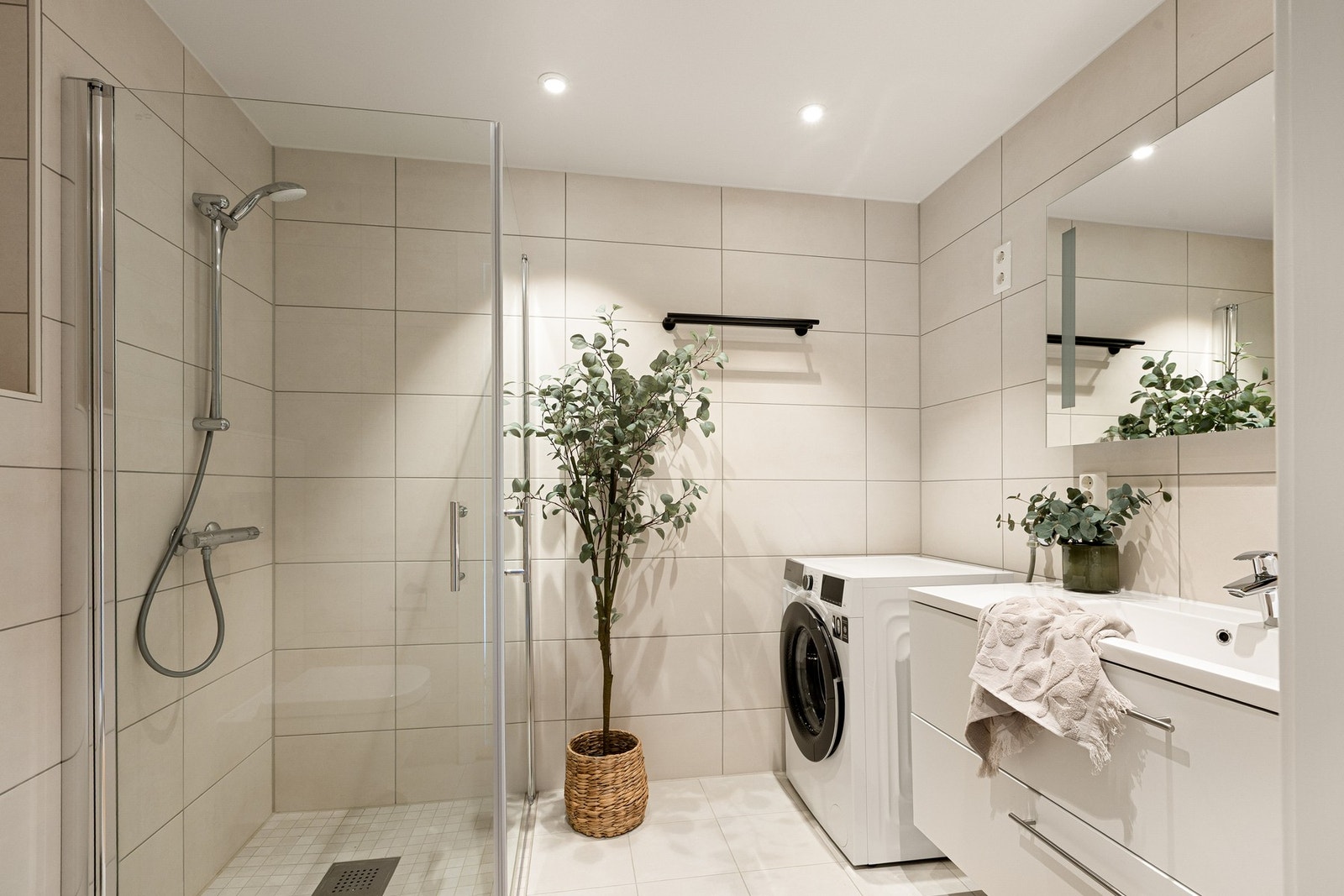 Delikat baderom med gulvvarme og opplegg for vaskemaskin og tørketrommel Galleribilde