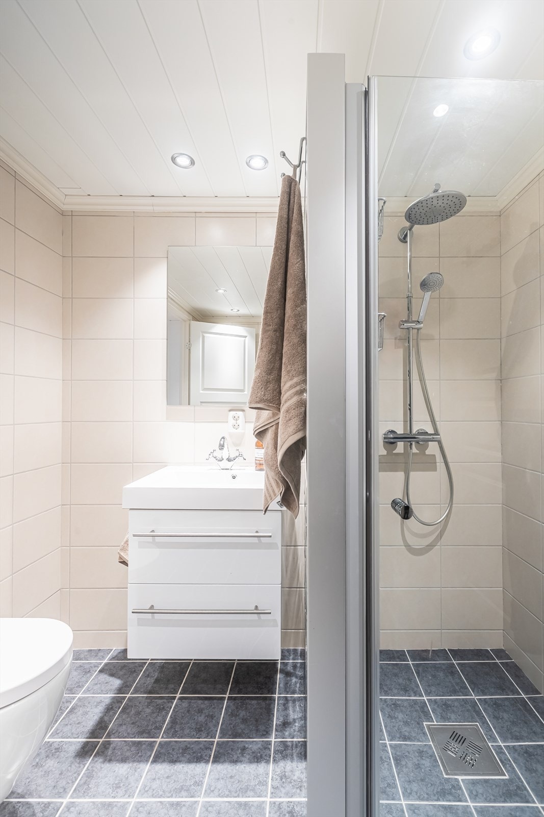 Bad i underetasjen med glass-vegger og veggmontert toalett gir en effektiv utnyttelse av baderomsarealet. Galleribilde