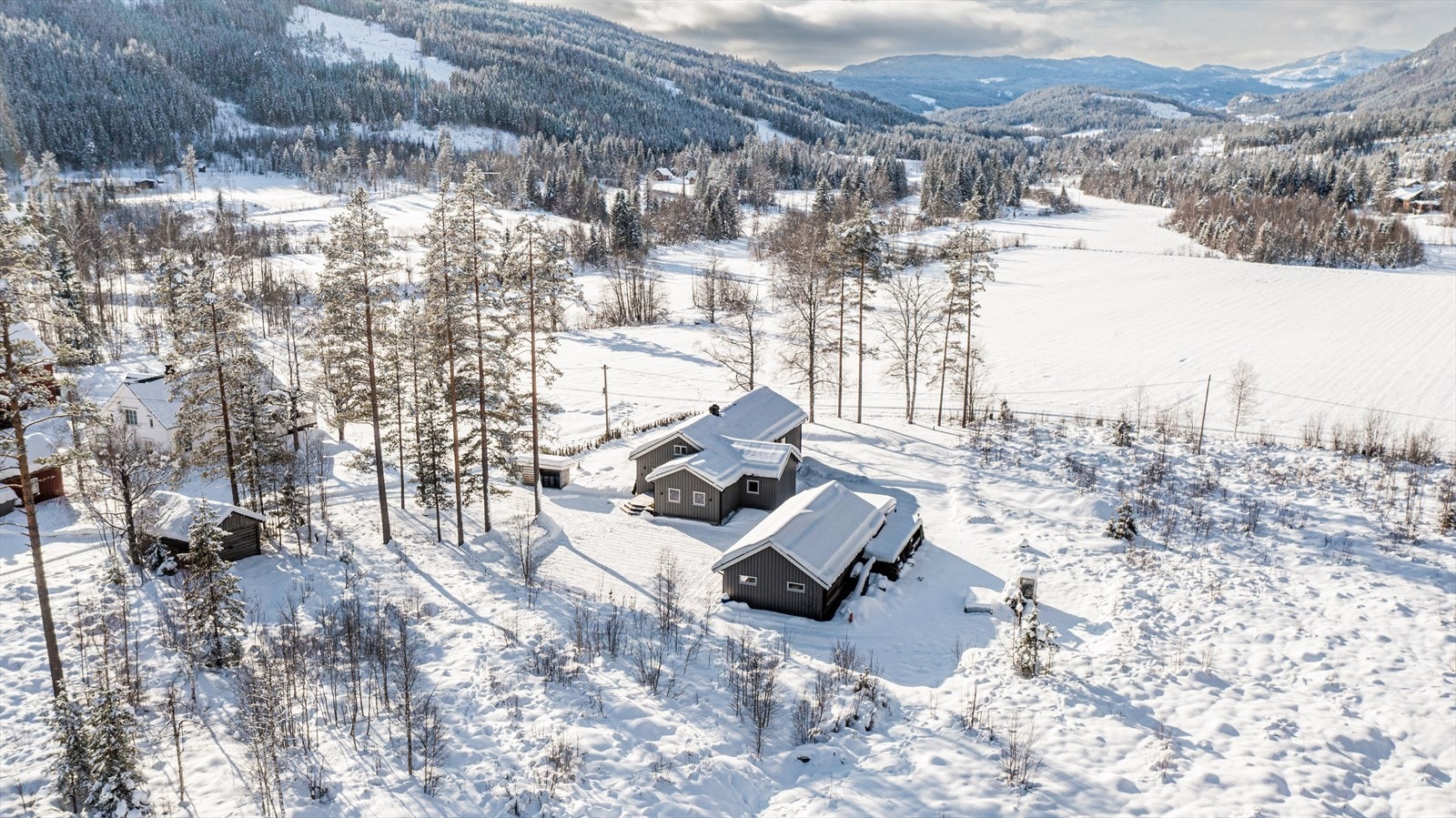 Eiendommen ligger i et spredt bebygd område og grenser til skog og jordbruksarealer. Galleribilde