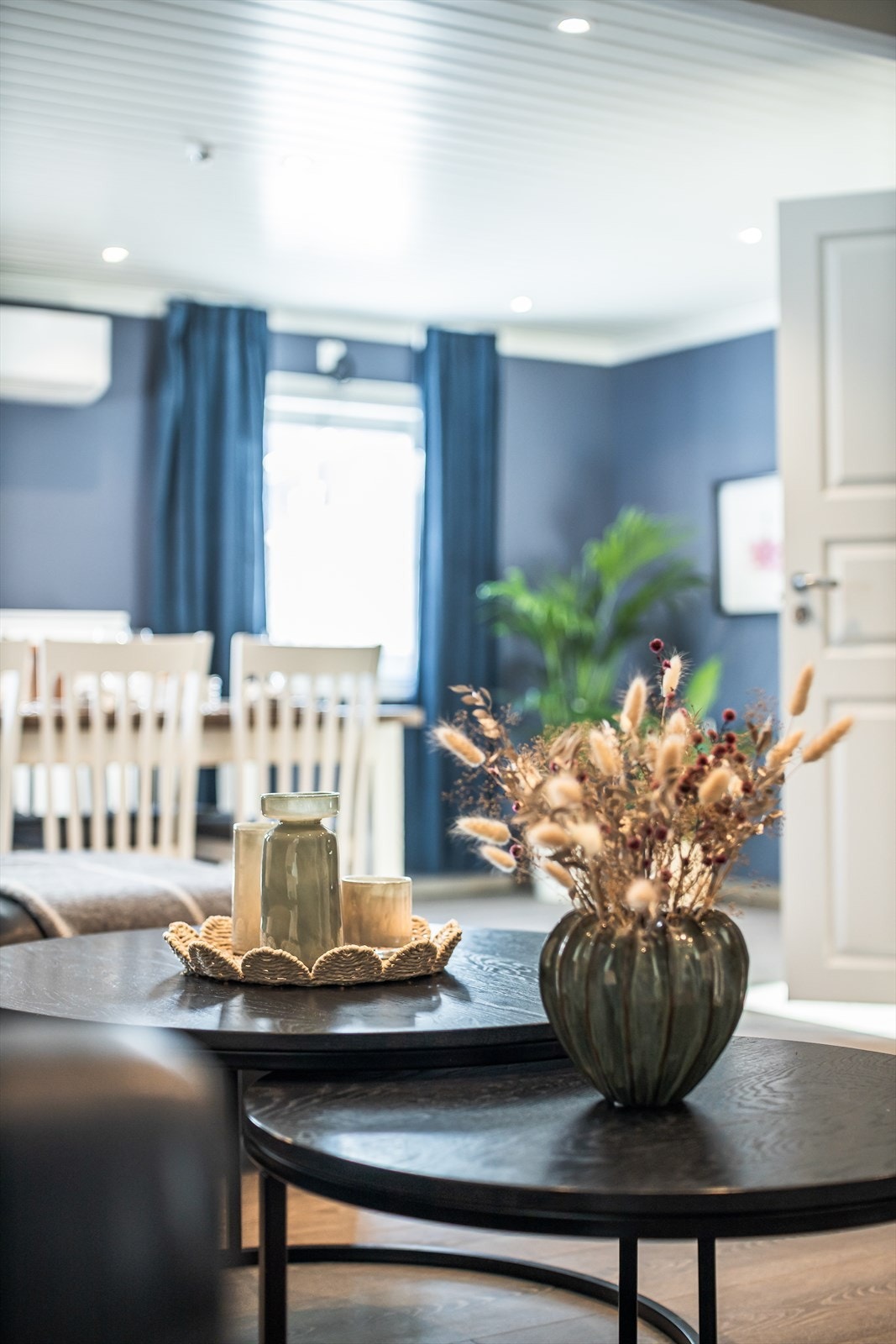 Laminatgulv og malte panelplater gir en stilren overflate i stuen. Galleribilde