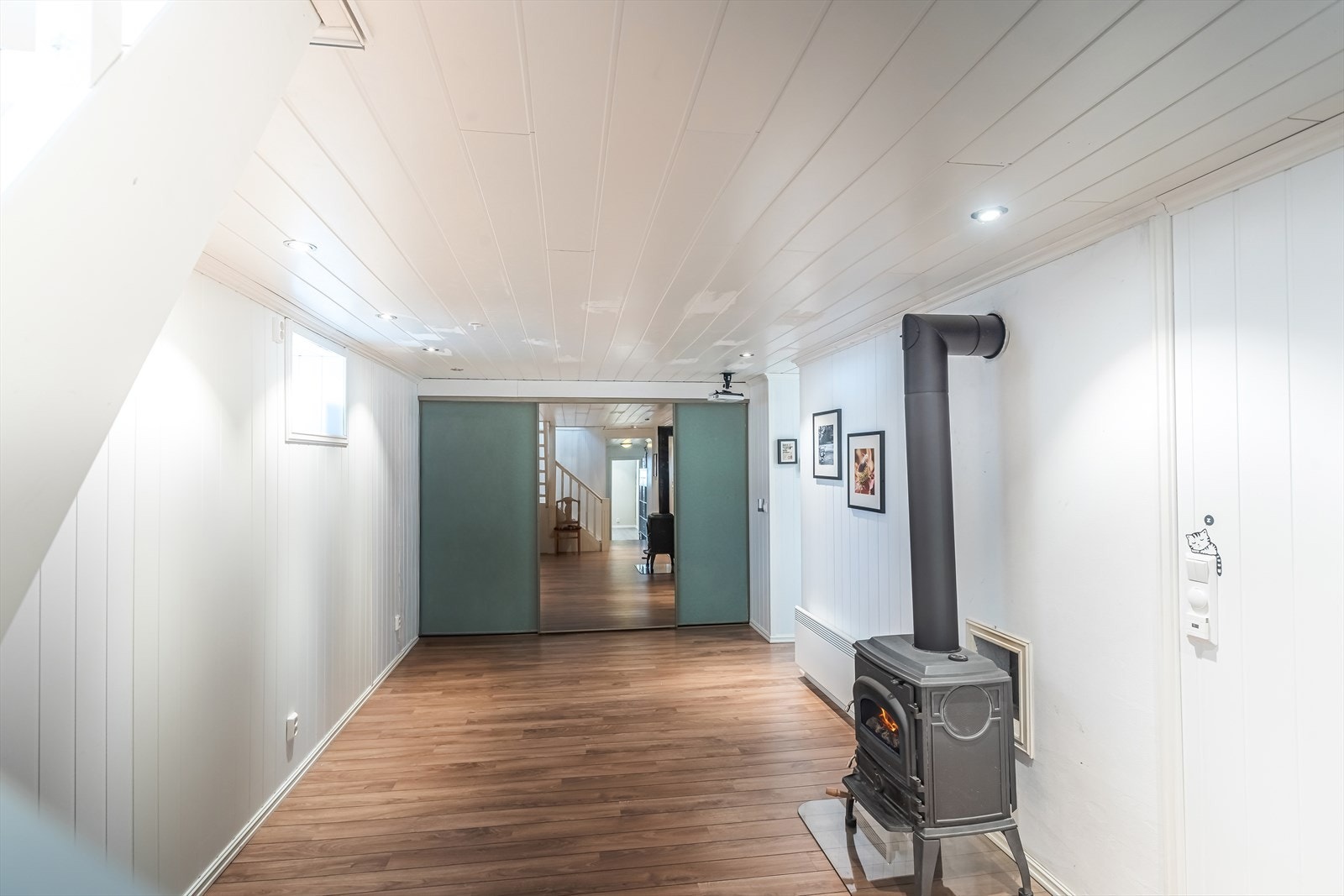 Kjellerstue med skyvedører åpner opp mot tilstøtende rom og gir fleksibel rominndeling. Galleribilde