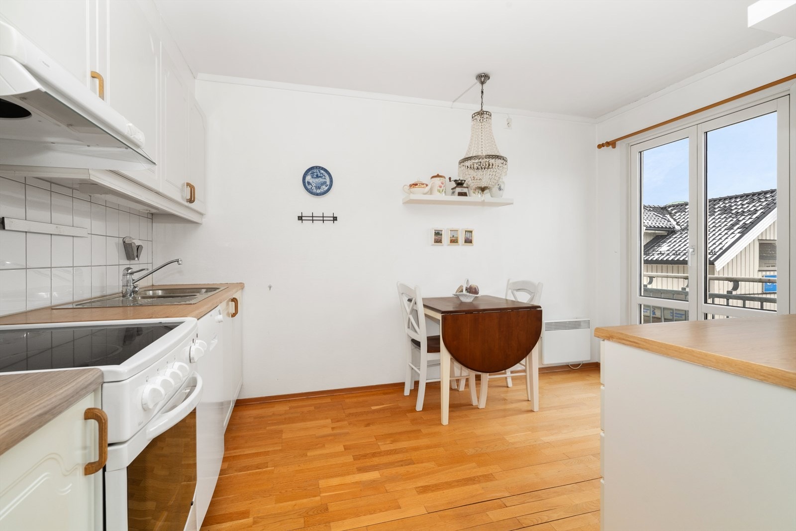 Romslig kjøkken med hyggelig spiseplass i forbindelse med vindu. Galleribilde