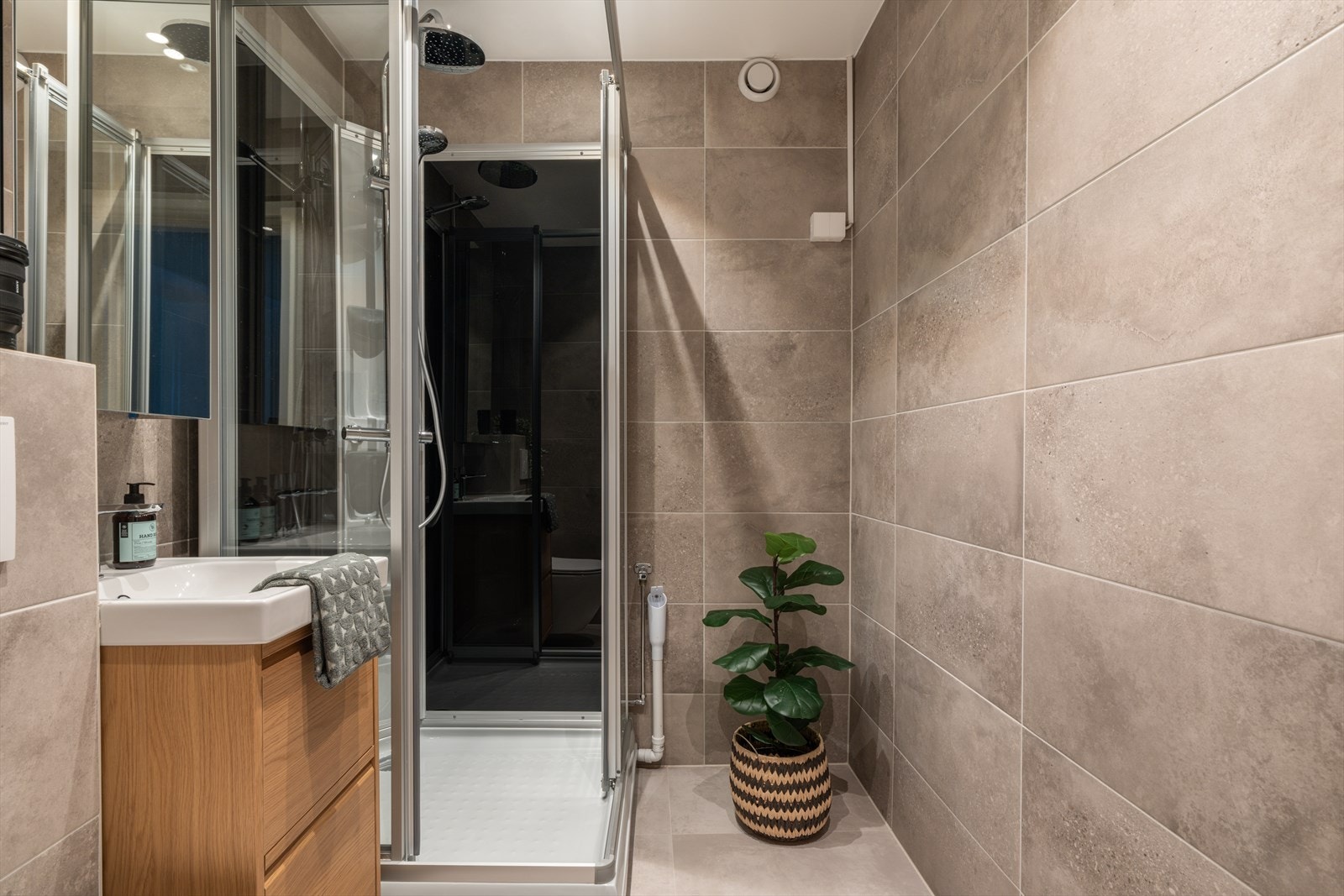 Badet fremstår som moderne med store delikate fliser og er overflate oppusset med flis på flis, ny innredning og 80x90 dusjkabinett med nisjer. Galleribilde