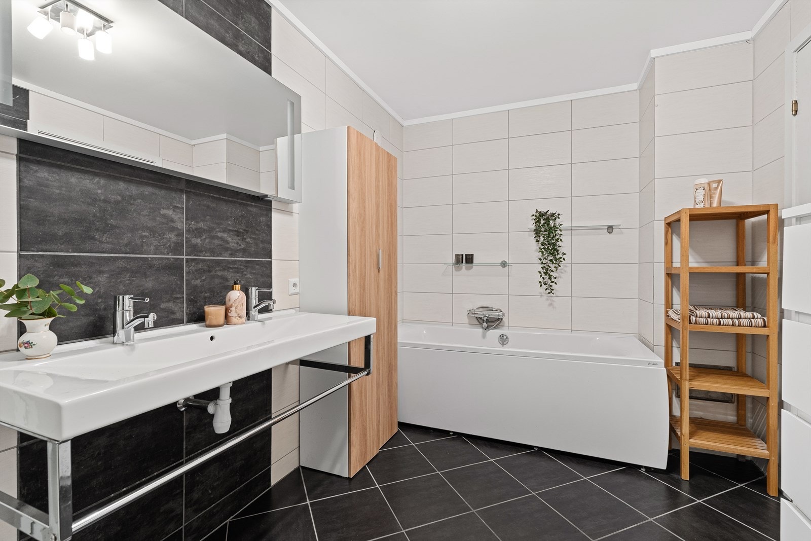 I boligens 1.etg. finner du et større helfliset bad med dobbel vask, badekar, dusjkabinett og vegghengt toalett. Det er varme i gulvet og ellers slett himling. Galleribilde