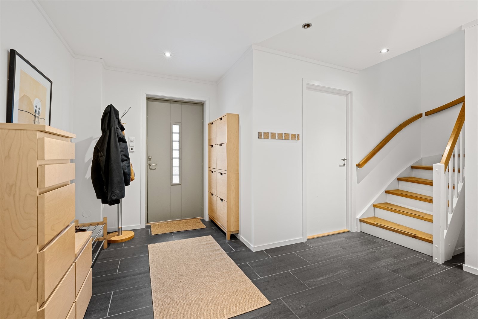 Velkommen inn! Boligen er gjennomgående lys og innbydende med slette malte gipsvegger og himlinger. I entreen er det fliser på gulvet med varmekabler, samt downlights i himling. Galleribilde