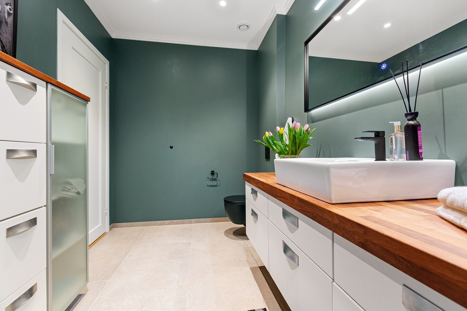 Pen innredet med baderomsservant, dusjkabinett, vegghengt toalett og skap. Galleribilde