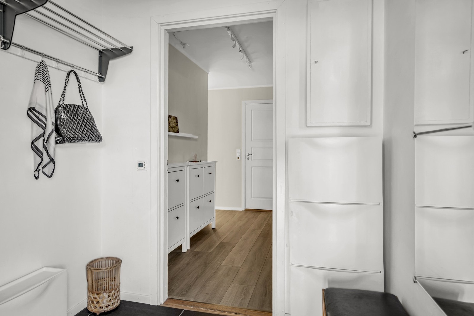 Romslig entré med flislagt gulv og gulvvarme - her er det montert hattehylle og skoskap. Galleribilde