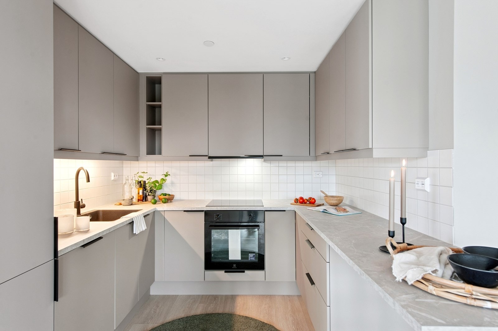 Innholdsrikt moderne kjøkken fra Aubo med god benkeplass. Påkostet med blant annet sort kum og kran i samme stil. Galleribilde