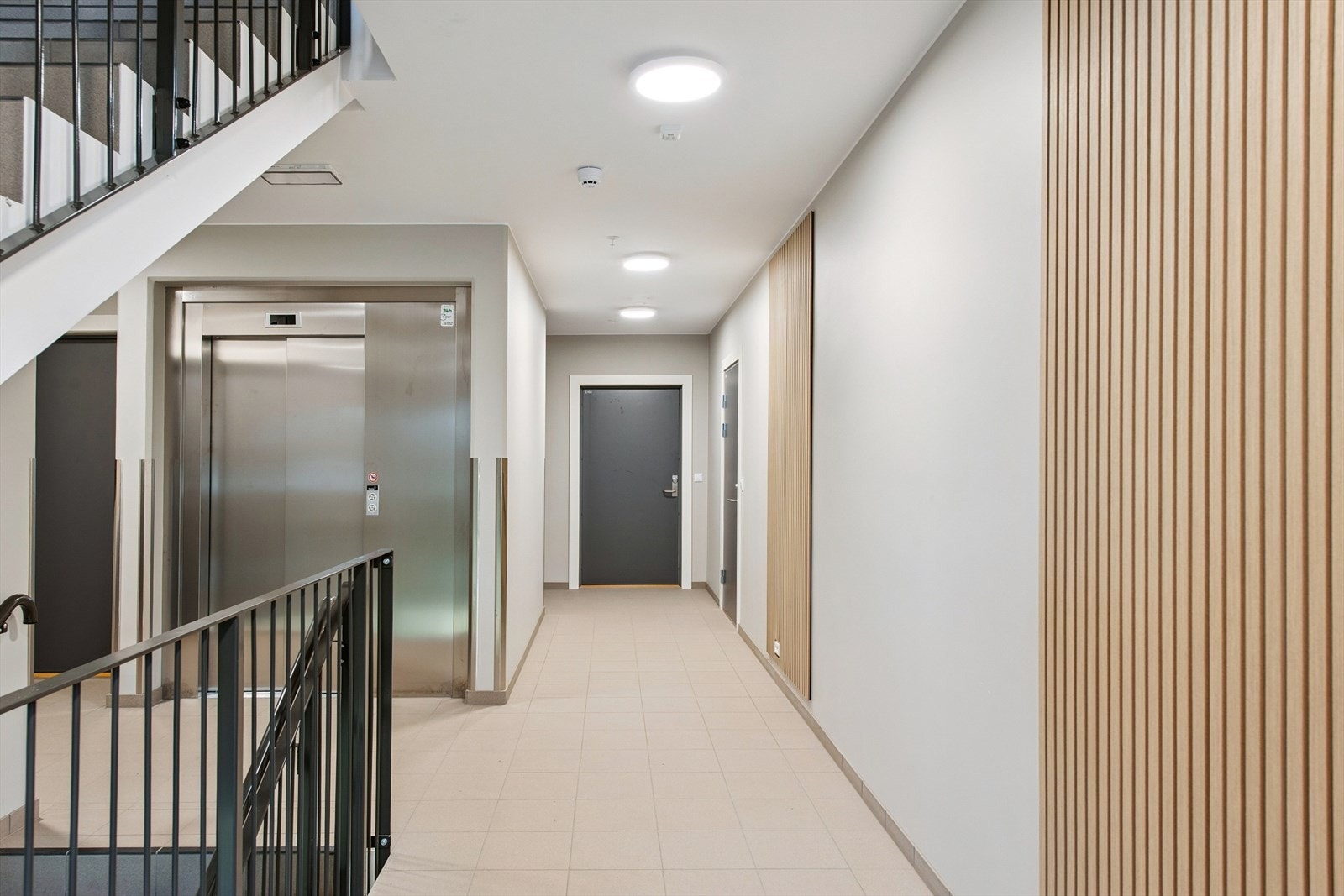 Innbydende fellesarealer med trapperom/heis, flislagt gulv og stilrene detaljer. Fra underetasje er det gang direkte til garasjeanlegget. Galleribilde