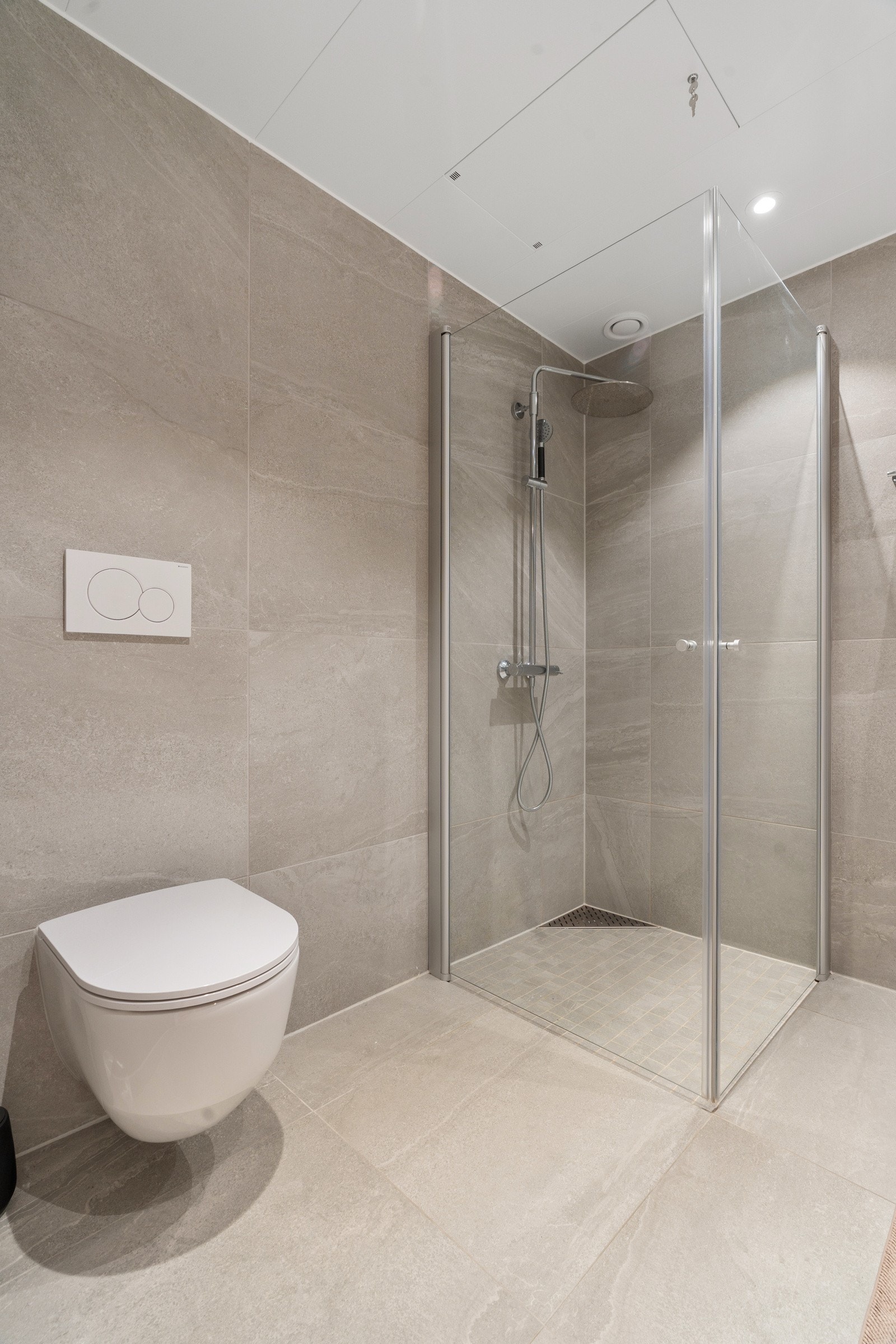 Praktiske løsninger som dusjhjørne med innfellbare dører og vegghengt toalett.