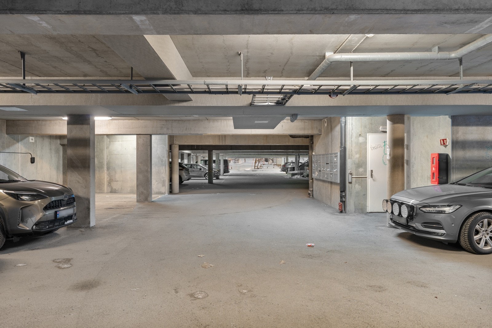 Fast parkeringsplass med elbil-lader i parkeringsanlegg.