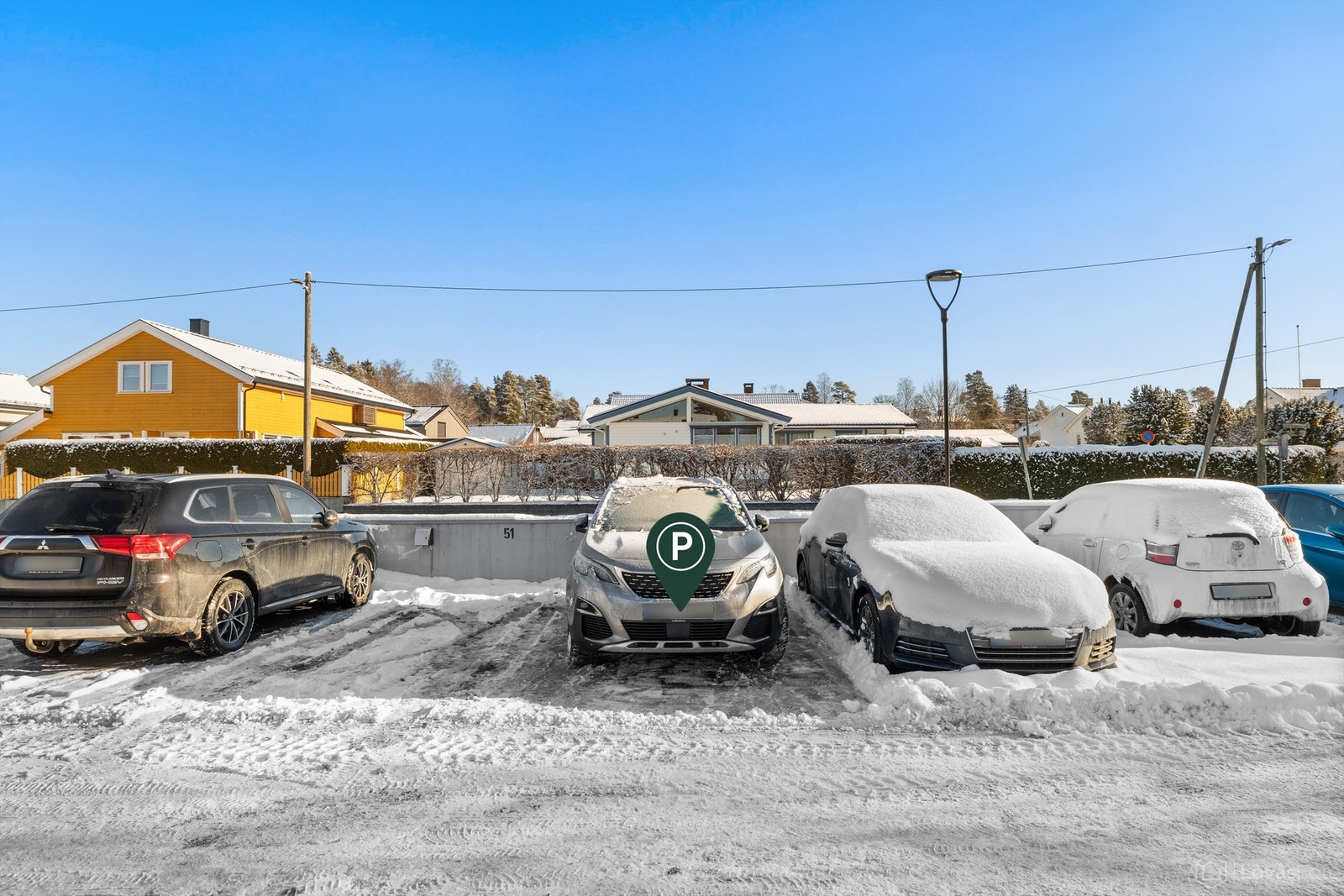 Det medfølger en parkeringsplass (nr. 50 ifølge selger) på taket av garasjeanlegget. Det er montert elbillader på plassen.
Oppmerkede gjesteparkeringsplasser på taket Galleribilde