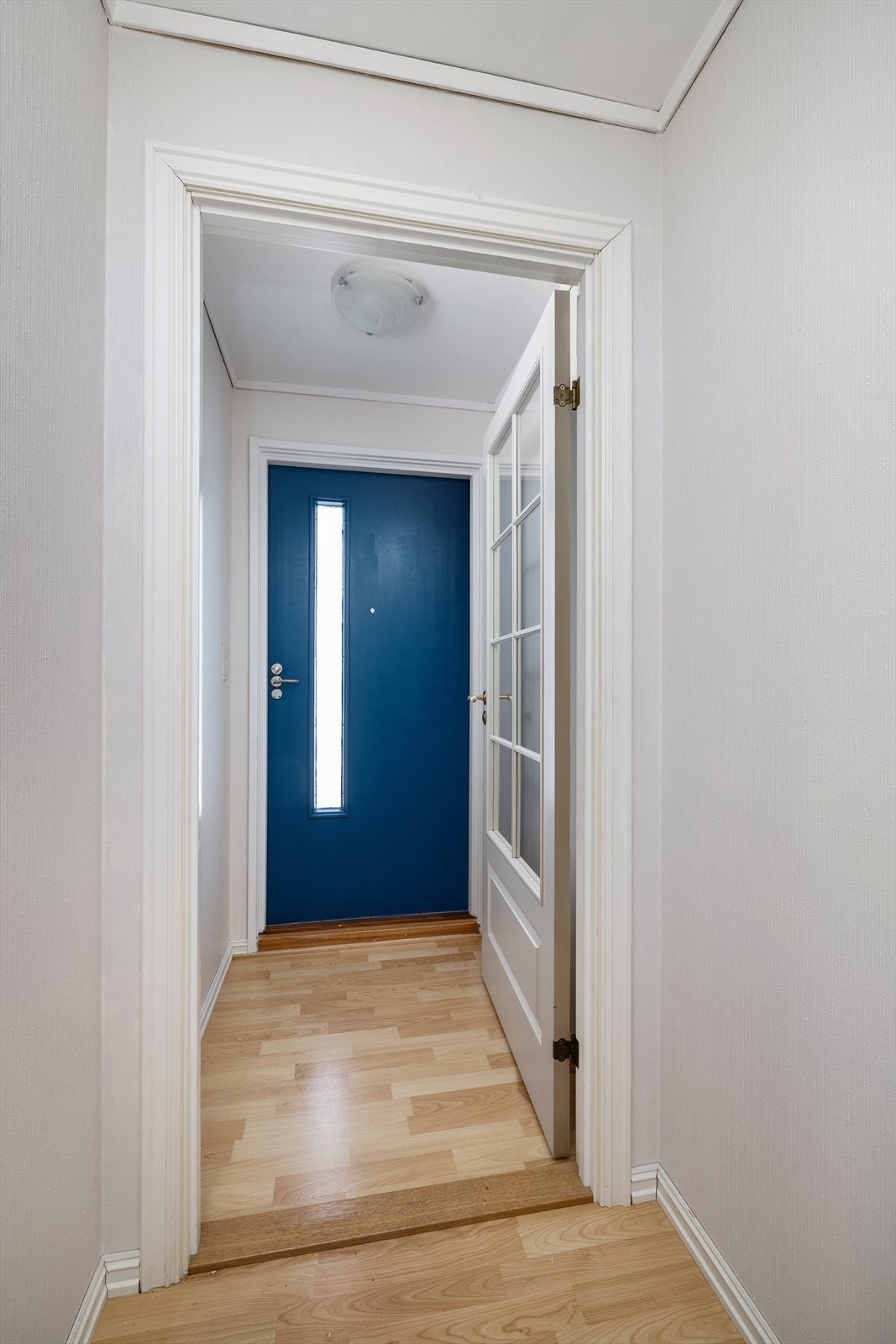 Lys entré. Ytterdøren har en solid, profilert utførelse. Galleribilde