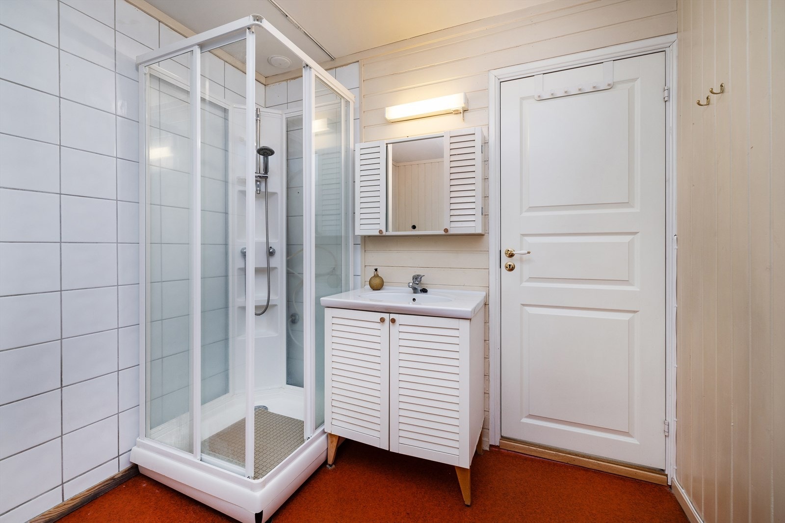 Badet i første etasje er utstyrt med servantinnredning, speilskap og dusjkabinett. Galleribilde