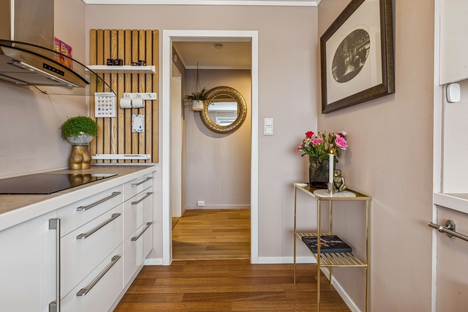 Kjøkkeninnredningen har glatte fronter og en vegghengt ventilator med avtrekk ut. Galleribilde